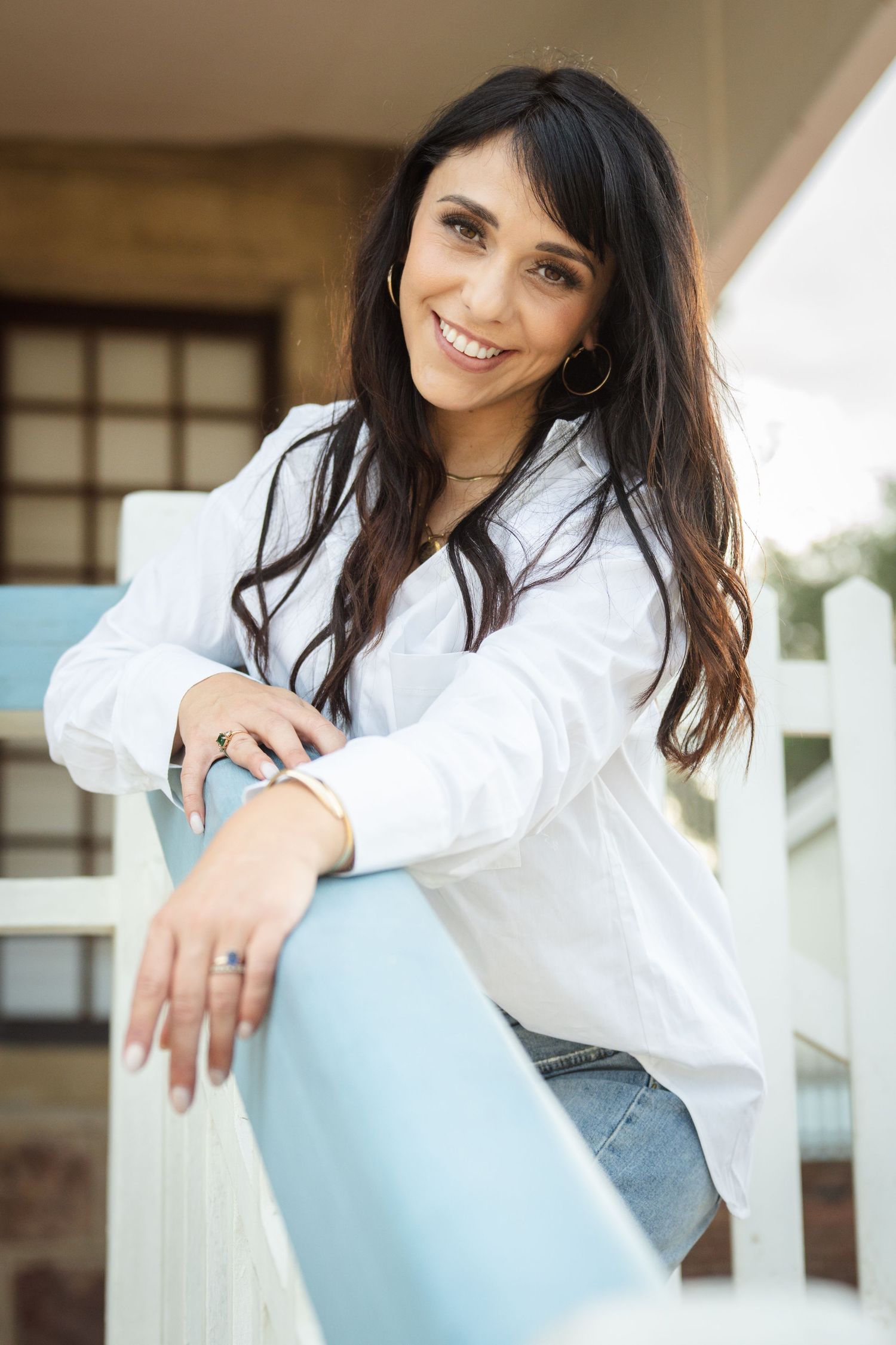 Woman leaning on a railing smiling during a lifestyle portrait session