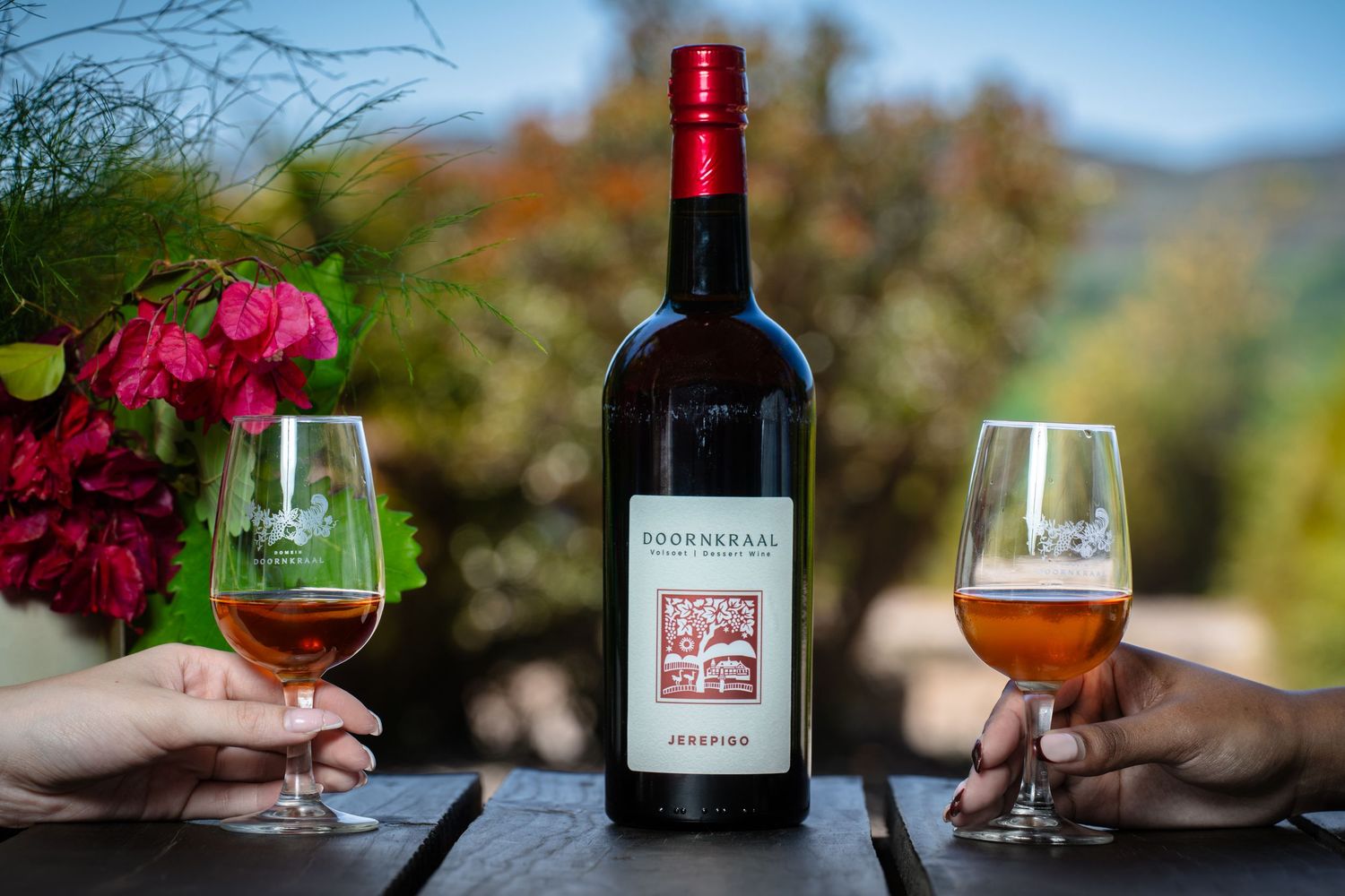 Doringkraal wine with 2 models holding glasses of the wine in their hands