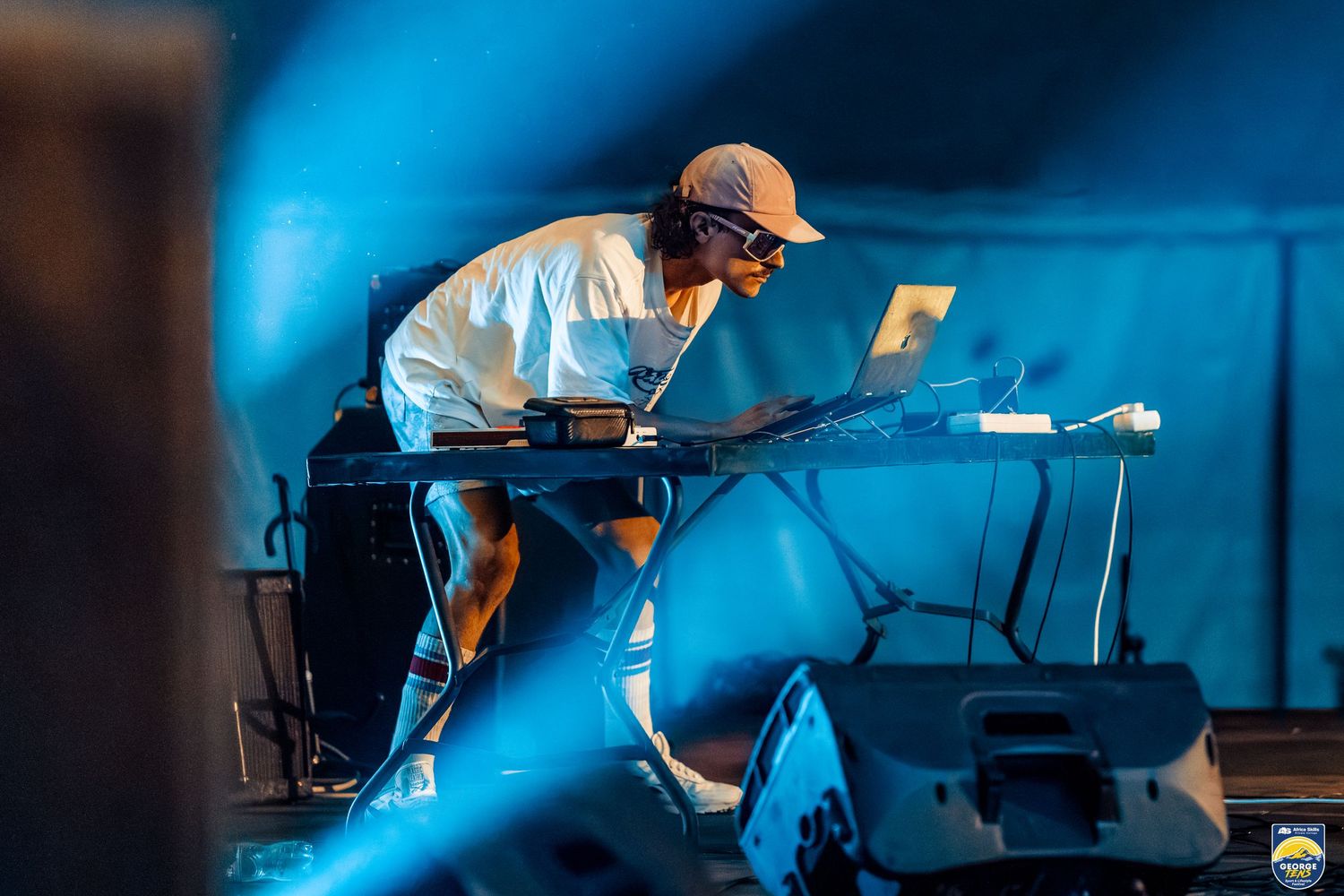Synth Peter performing at the George Tens with blue stage lights framing him