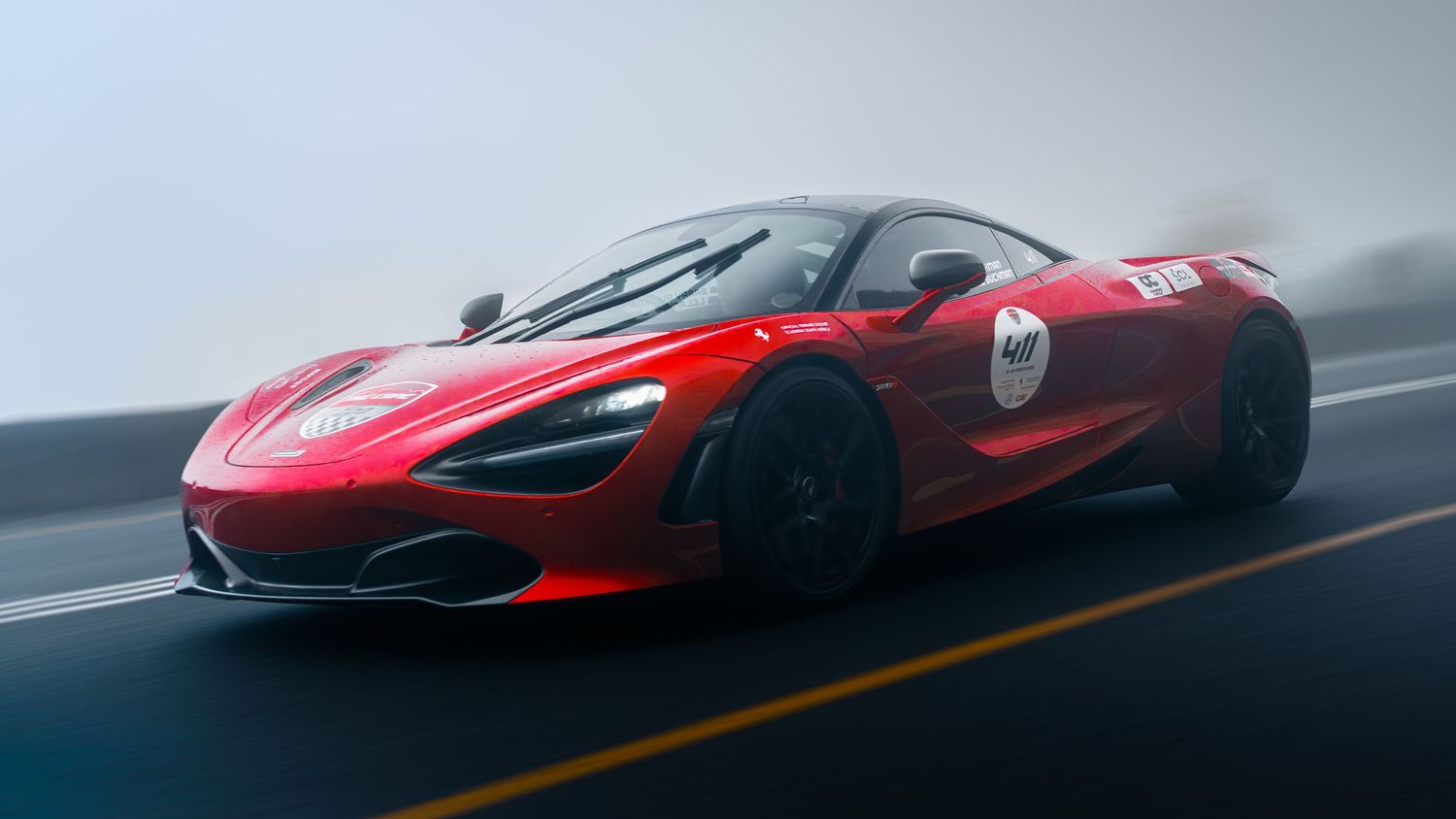 Red McLaren 720S supercar speeding on a misty highway, showcasing its aerodynamic design and racing livery.