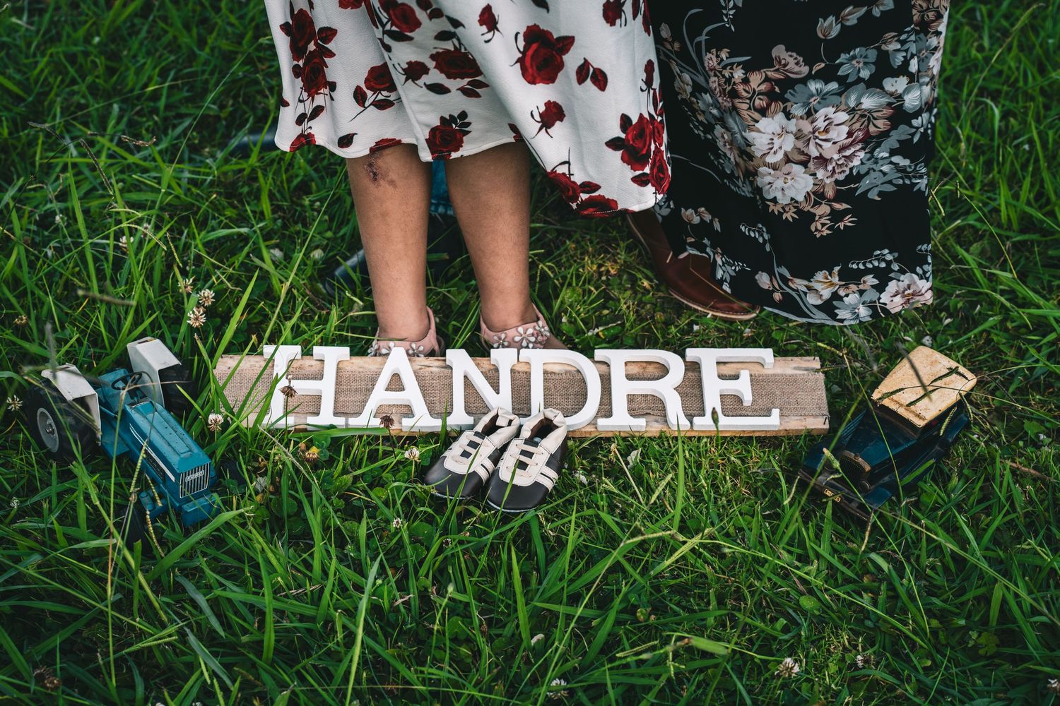 Floral dress details and grass background in an outdoor summer setting.