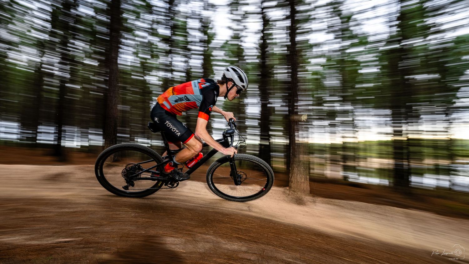 A panning photo of a professional cyclist on a berm