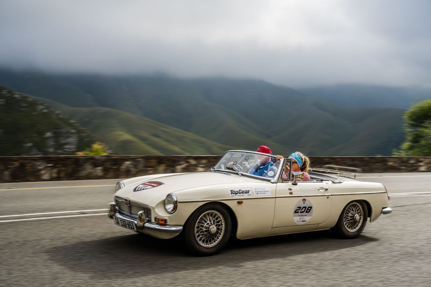 Classic convertible driving along a scenic mountain road in South Africa