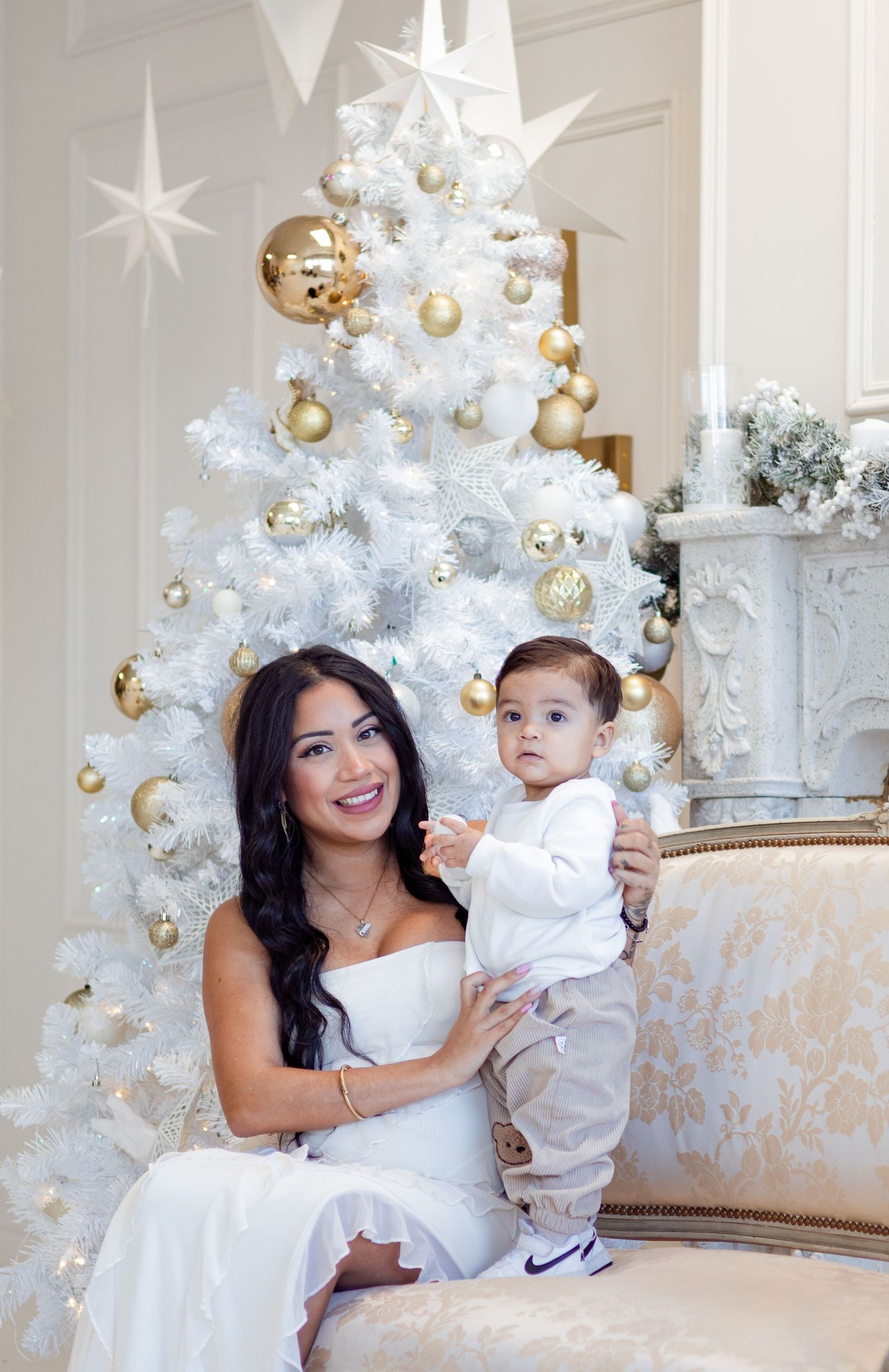 Holiday portrait session with white Christmas decor and elegant vintage furniture.