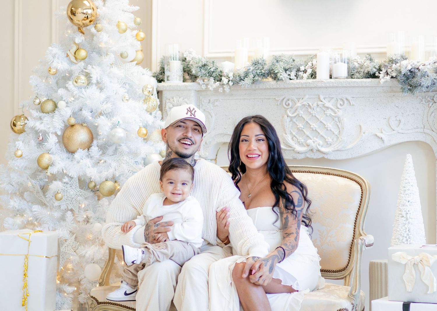 Holiday family photoshoot featuring coordinated white outfits against white Christmas decor.