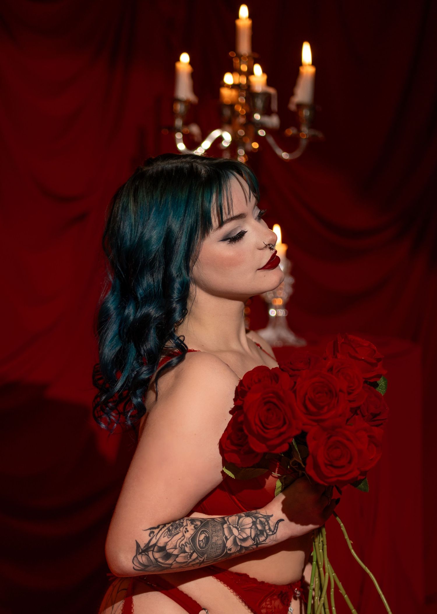 A moody series of photos with lit candles, red roses, and dark blue hair against a deep red background.