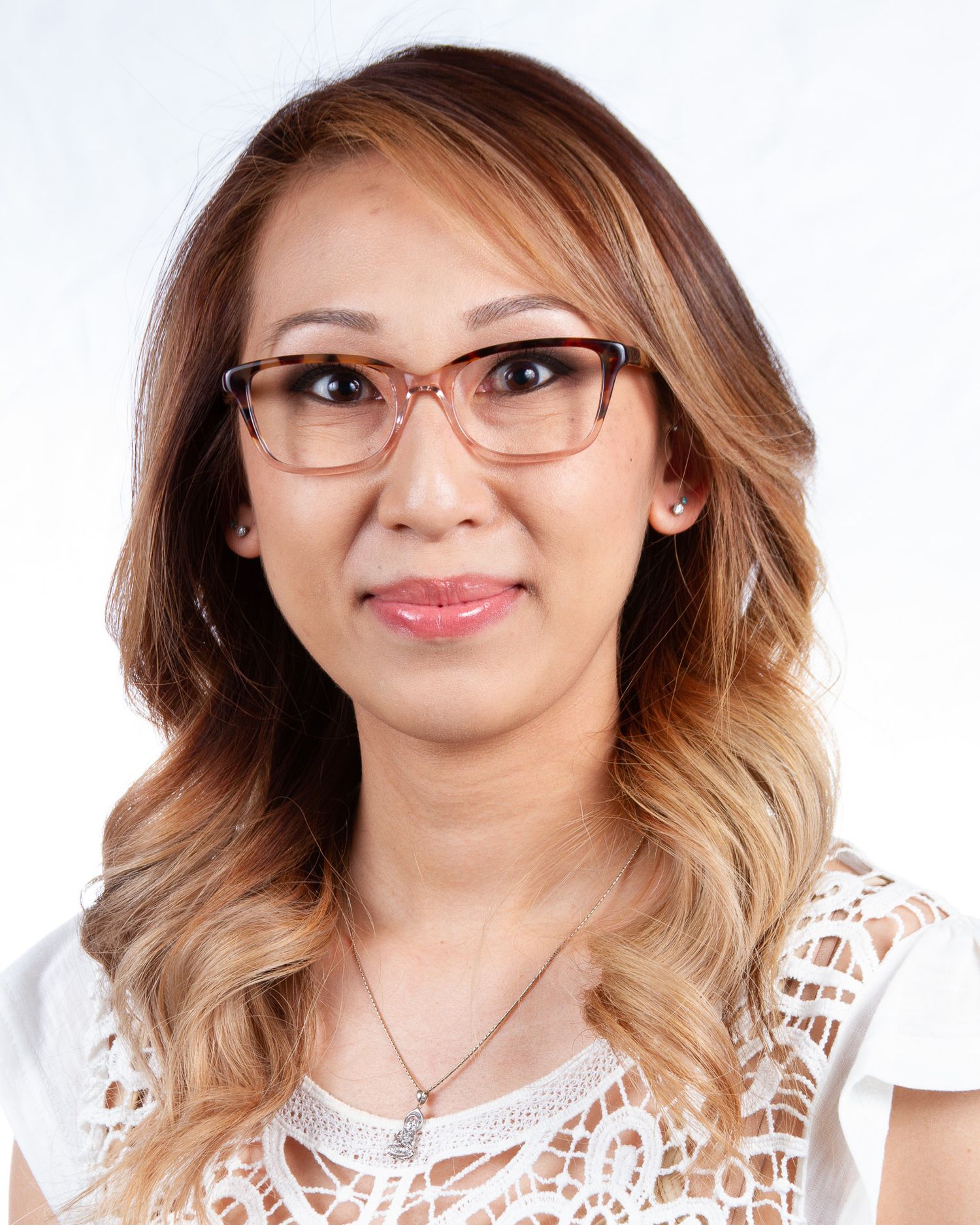 Studio portraits in white lace top against clean white background.