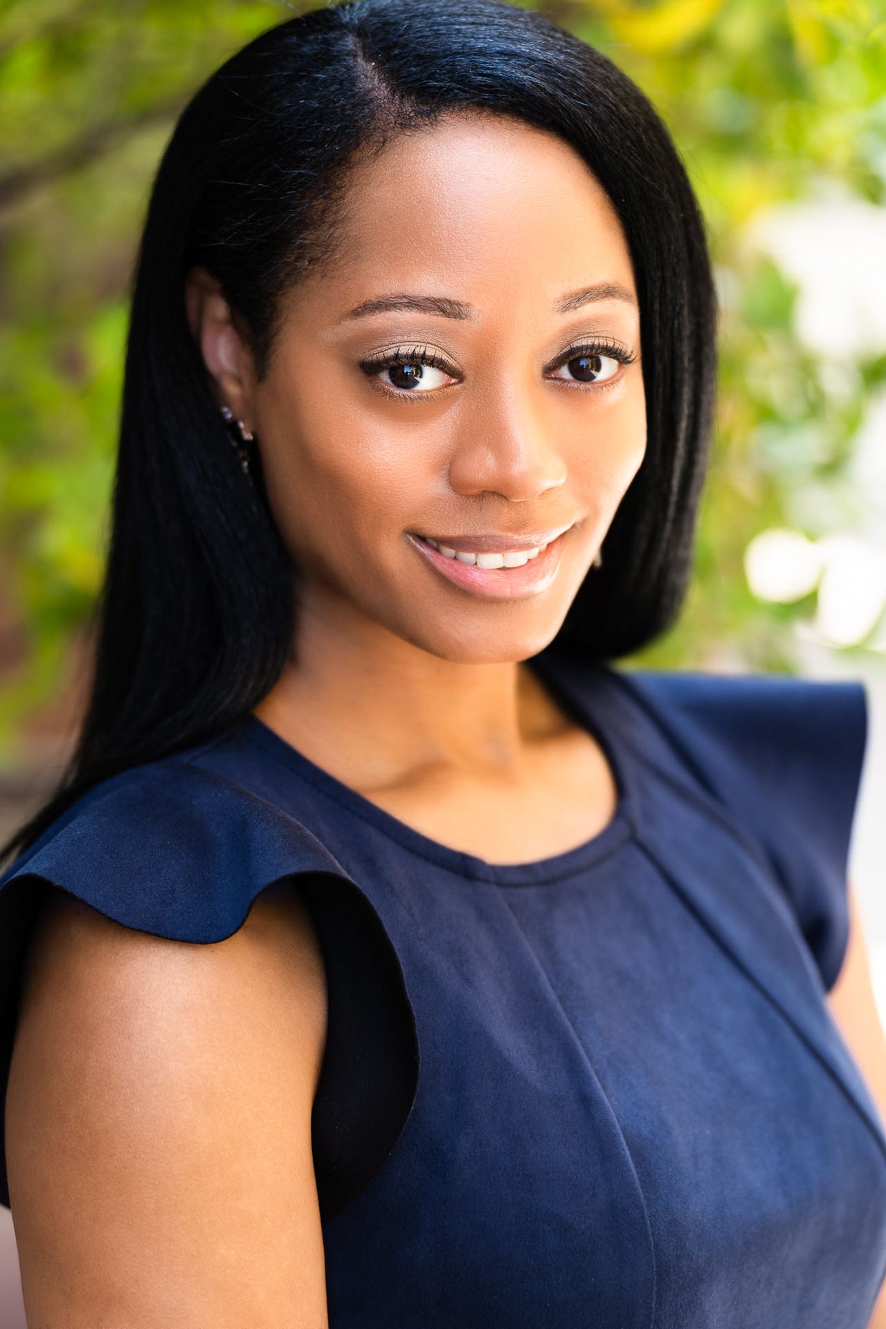Professional headshots featuring navy blue attire against a bright outdoor background with bokeh effect.
