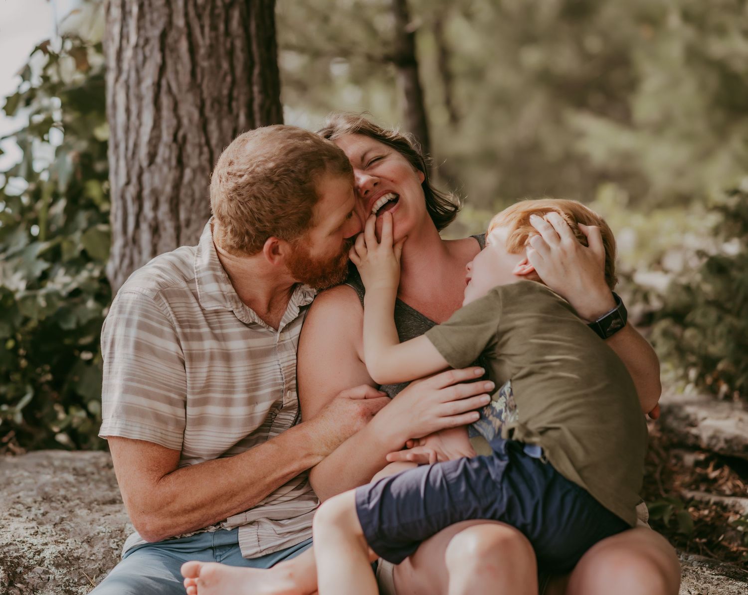 A candid outdoor family moment filled with laughter and joy while sitting together in nature- taken By Ashlee Ellison Photography