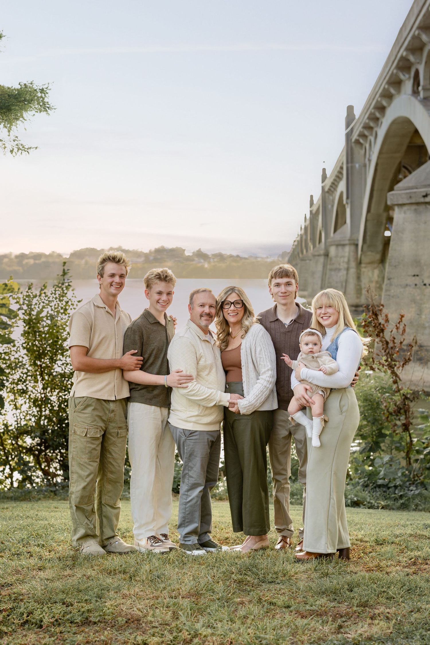 A luxury portrait session by Megan Mariah Photography, PA features an extended family posing by a historic bridge in Wrightsville, PA.