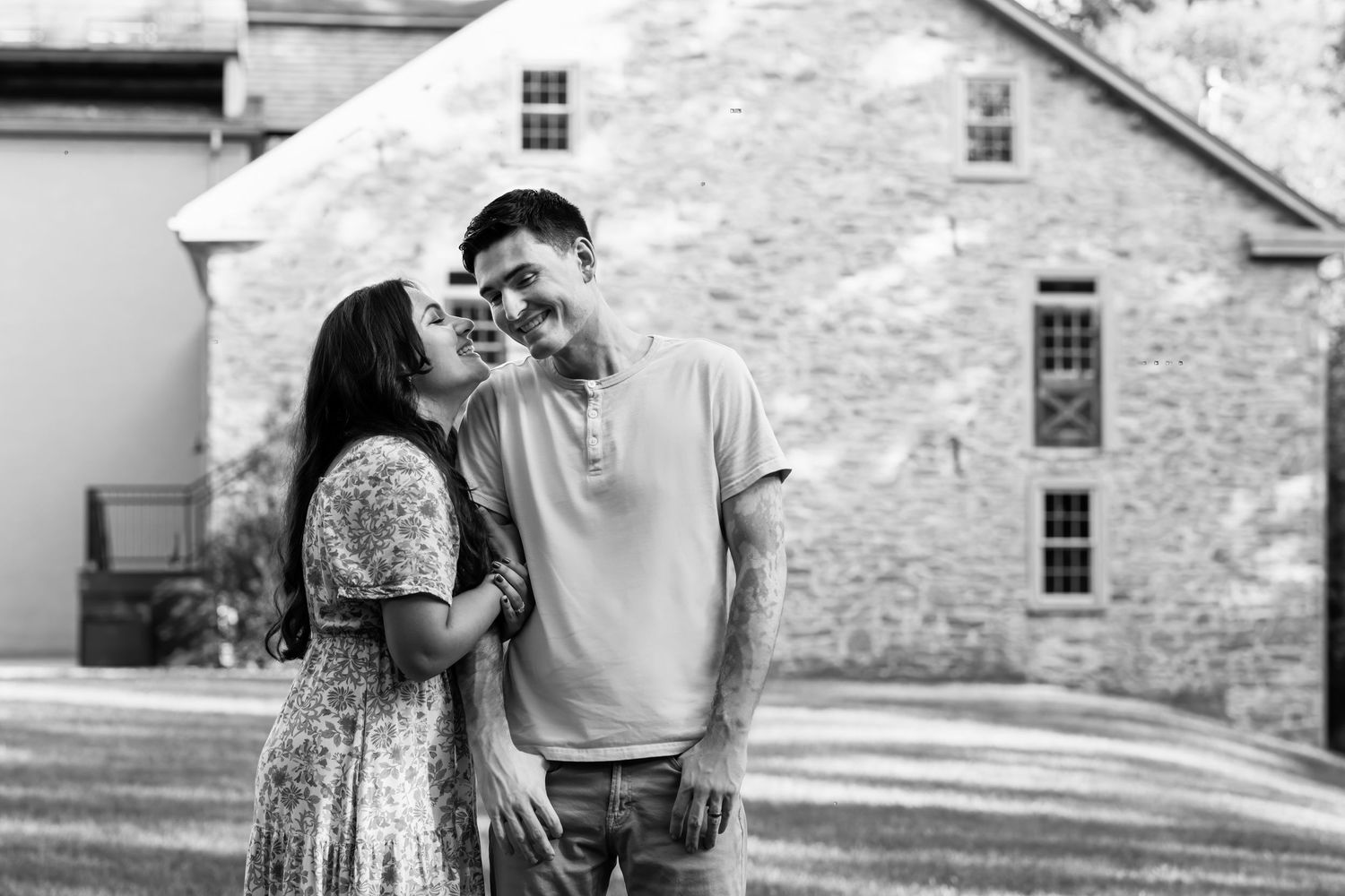 A black and white image of a couple in love, a joyful, candid moment, by Megan Mariah Photography in Lancaster, PA.