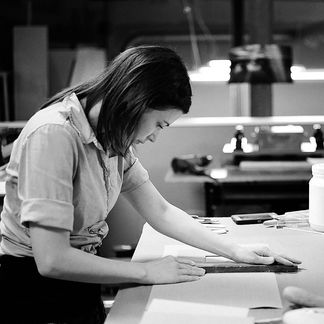 A black and white image of a designer hand crafting an heirloom album for senior and family photography clients in Lancaster, PA.