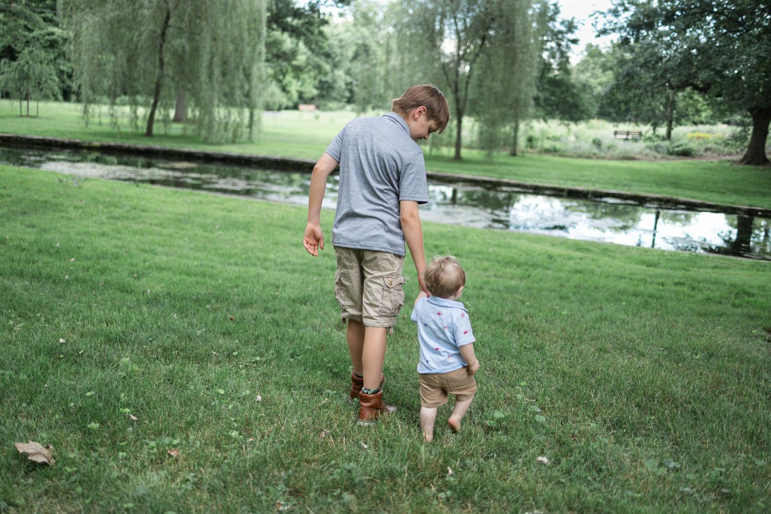 Older brother walking hand in hand with toddler brother during a family photography session at Donegal Presbyterian Church in Mount Joy, PA