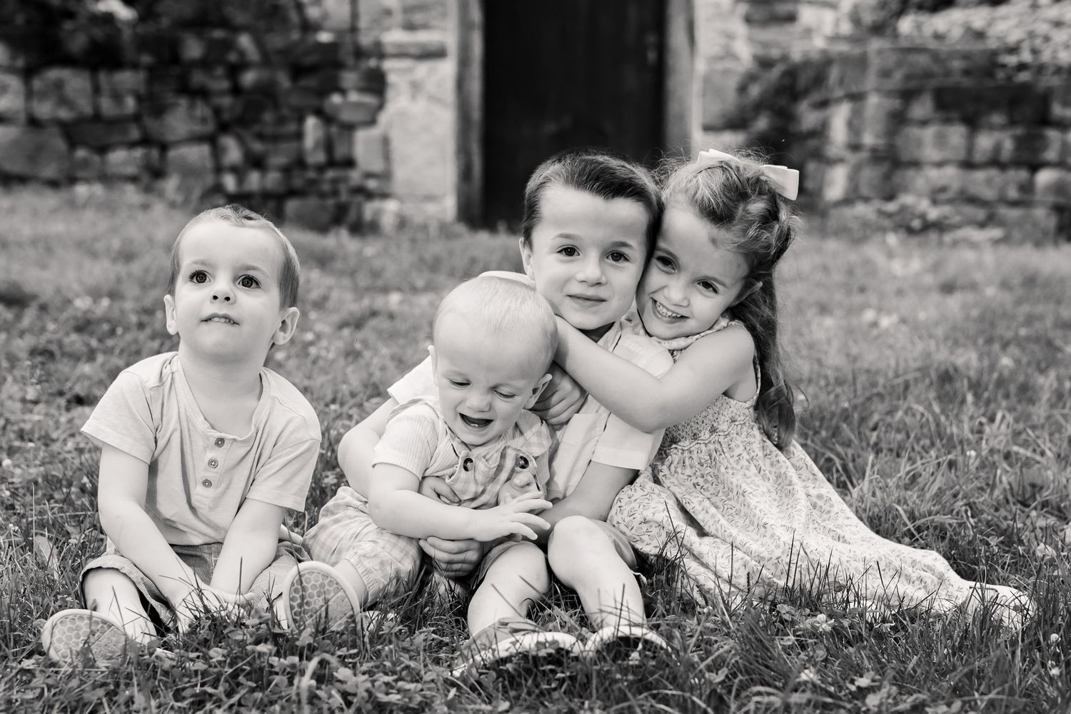 Candid black and white portrait of four siblings | luxury family packages by Megan Mariah Photography
