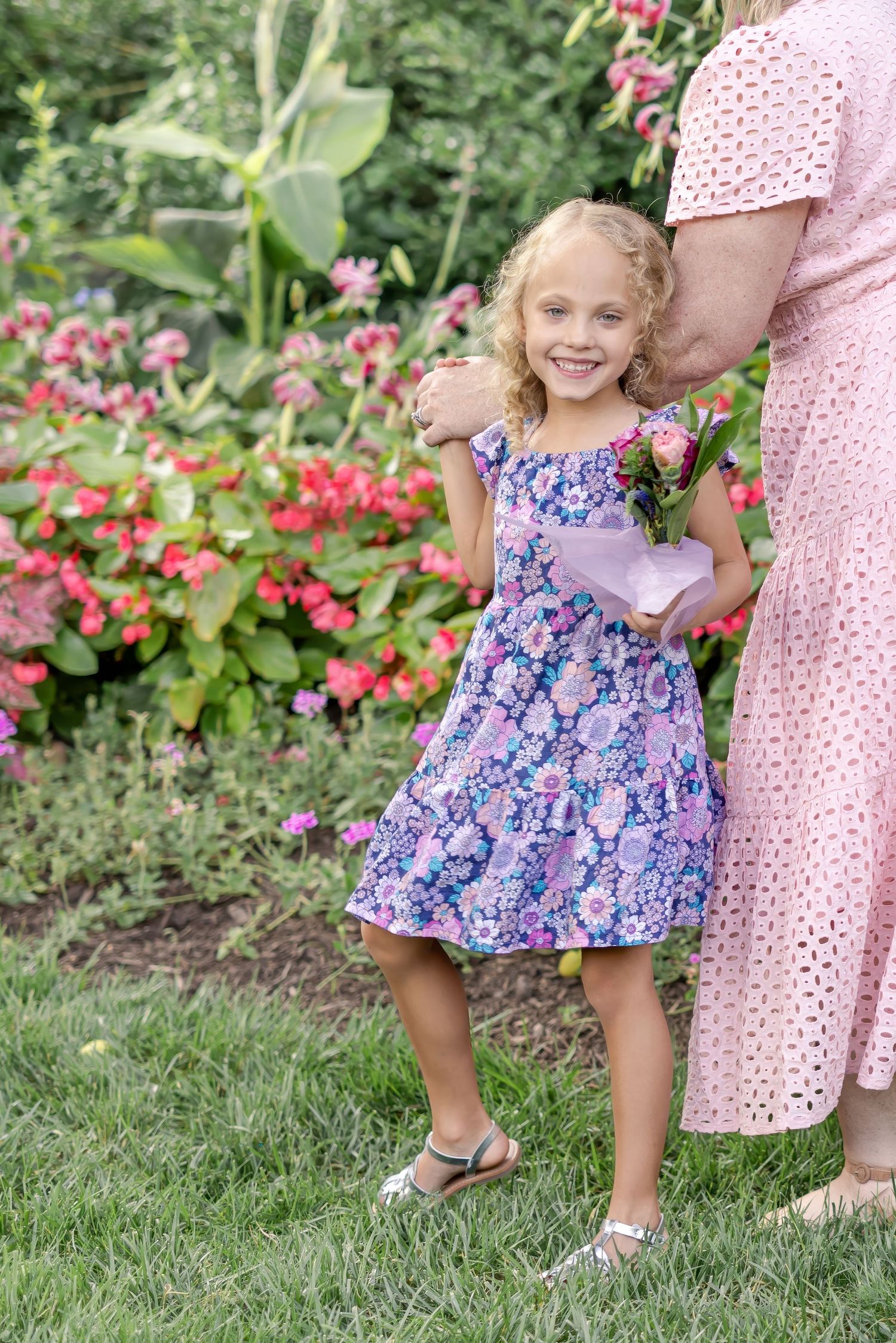 A young girl holds her mother's hand while smiling at the camera during mother-child photos in Lancaster, PA.