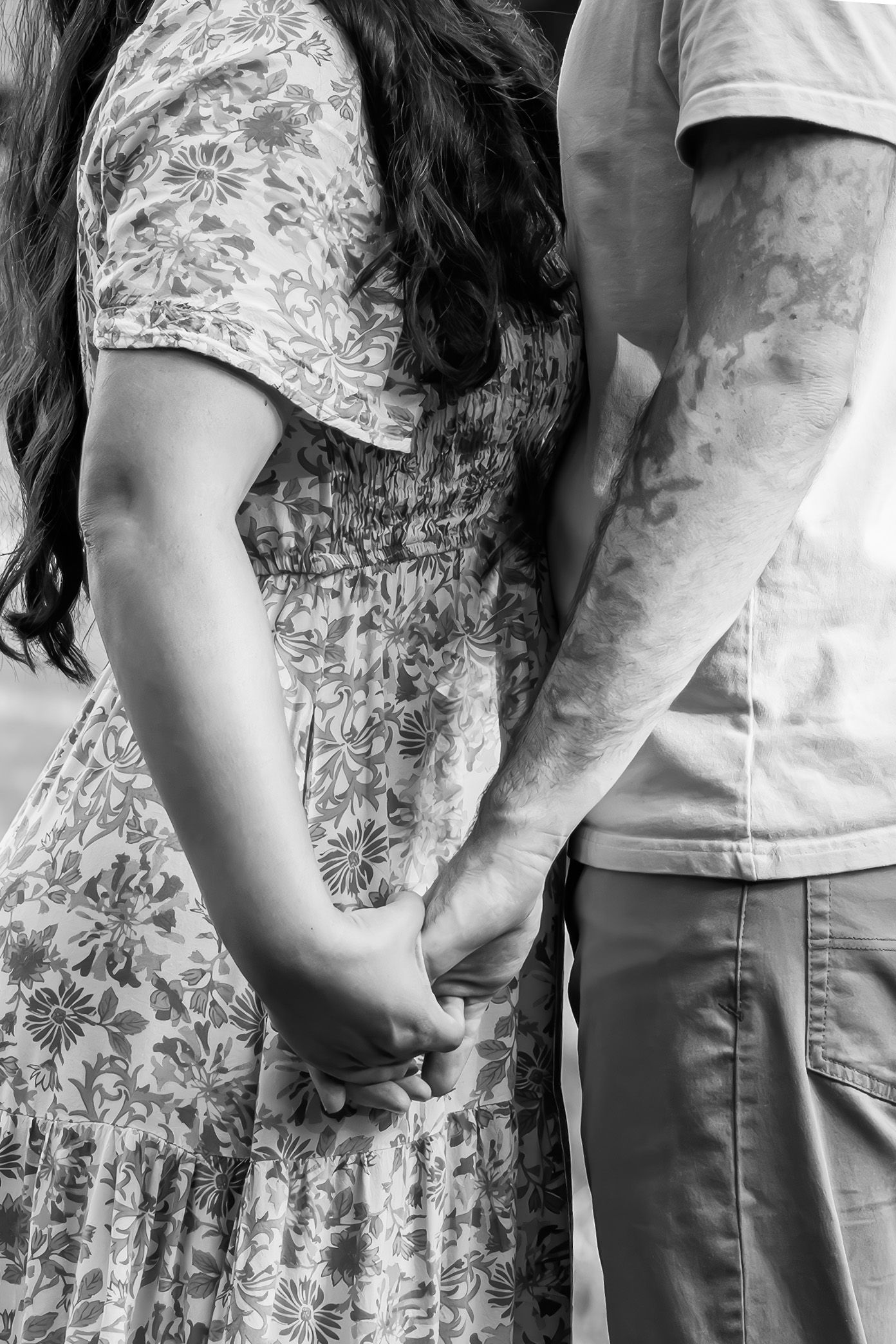 A couple in casual attire holds hands close-up, during a summer family photo session in Lancaster, PA.