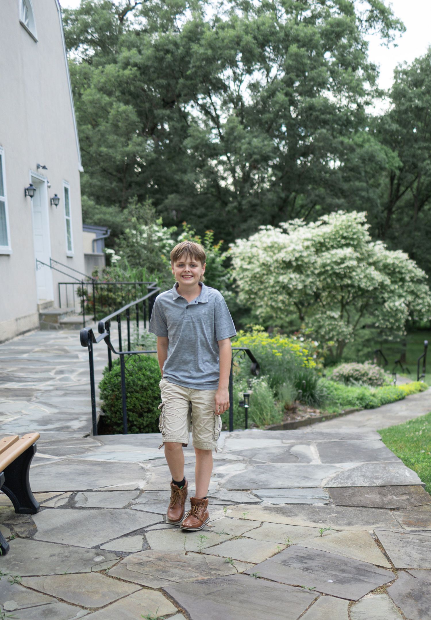 teen boy walks on stone path at Donegal Presbyterian Church in Mount Joy, PA during family session with Lancaster, PA photographer