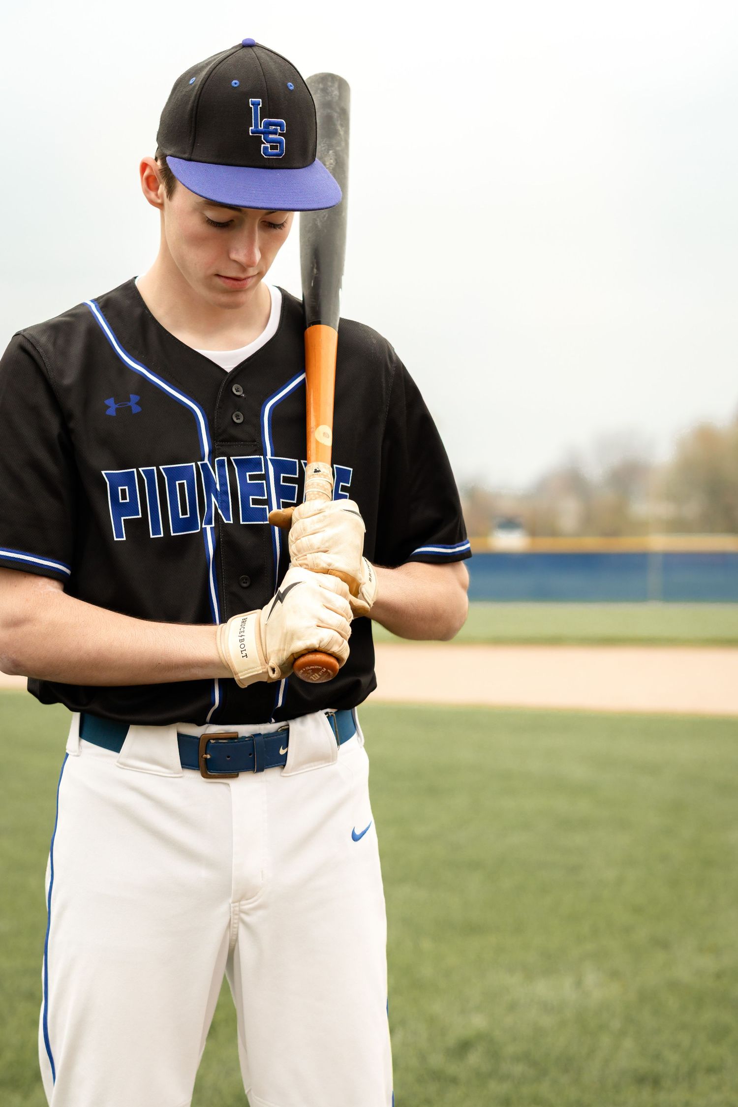 Senior boy in baseball uniform posed with baseball bat | luxury senior photography in Lancaster, PA
