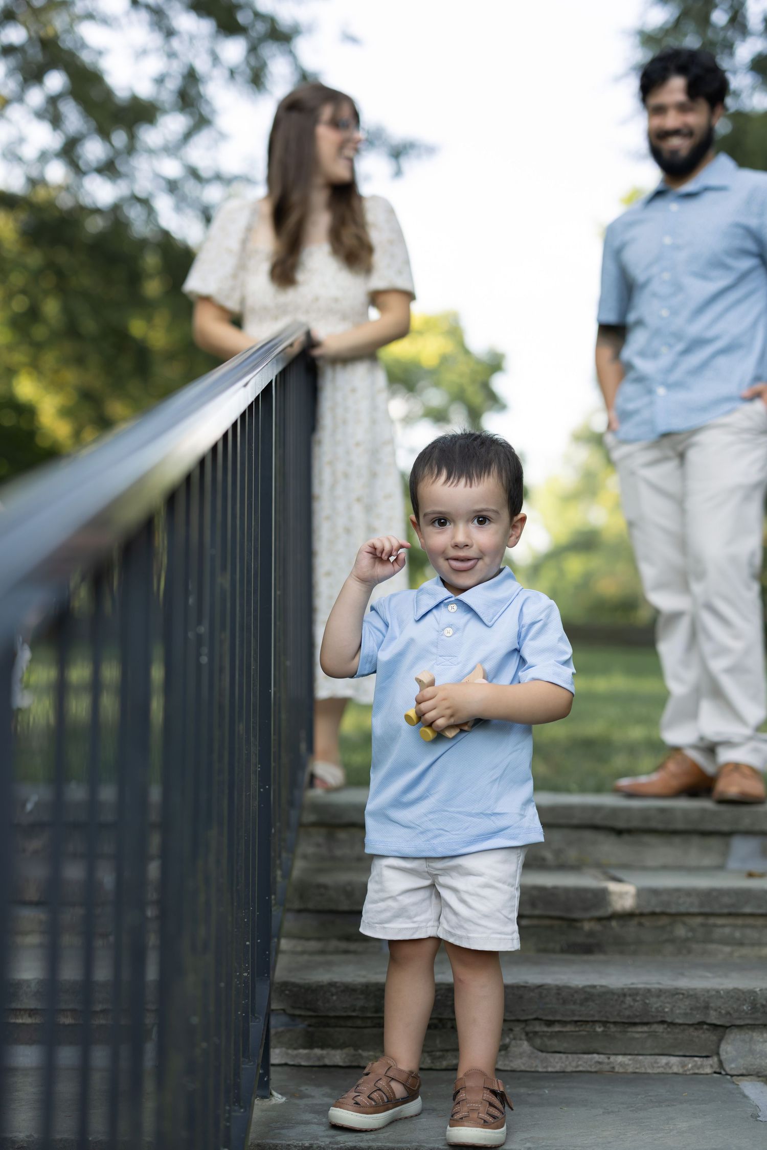 Family of four enjoying luxury portraits in the formal gardens of Conestoga House