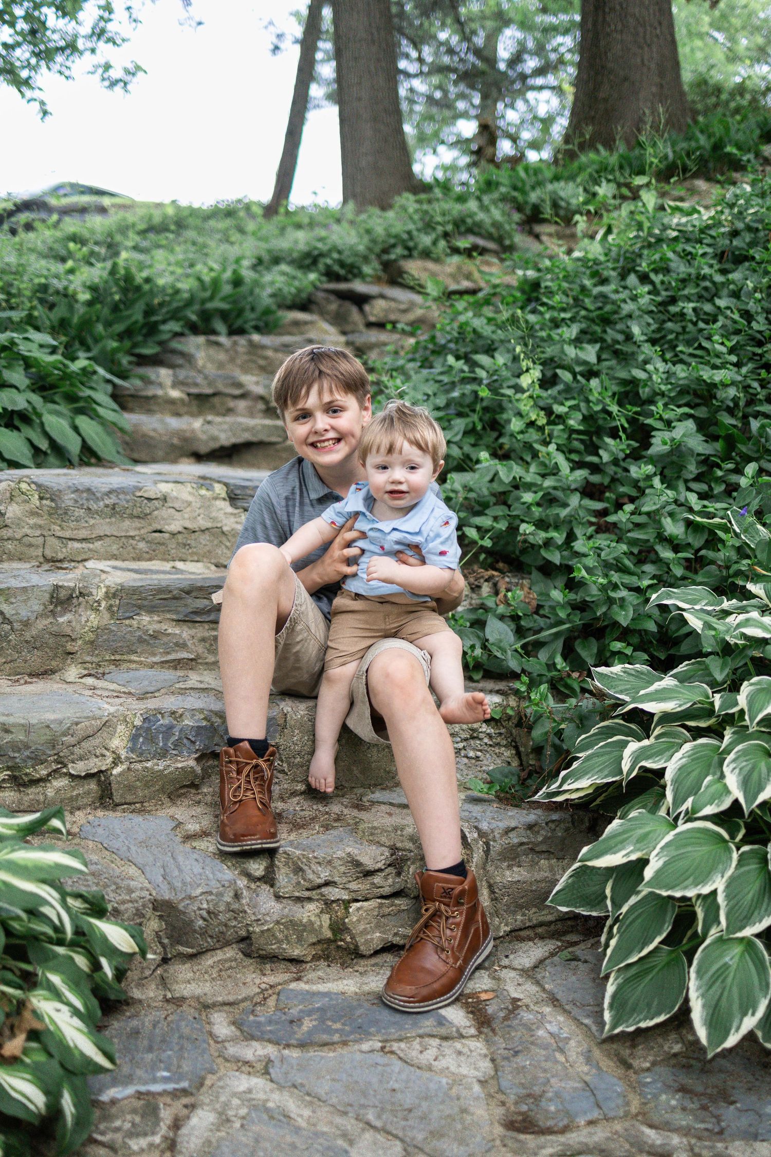 Two brothers sit on stone stairwell at Donegal Presbyterian Church in Mount Joy, PA during a family photography session in Lancaster, PA.
