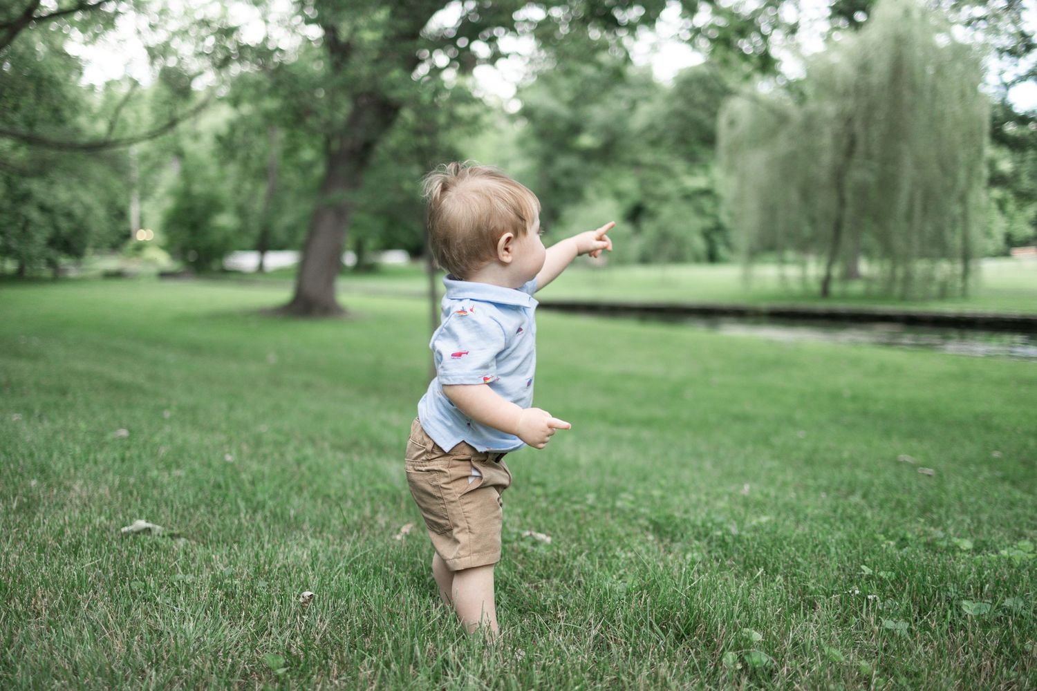 Toddler in white and blue taking first steps on green grass at Donegal Presbyterian Church in Mount Joy, PA.
