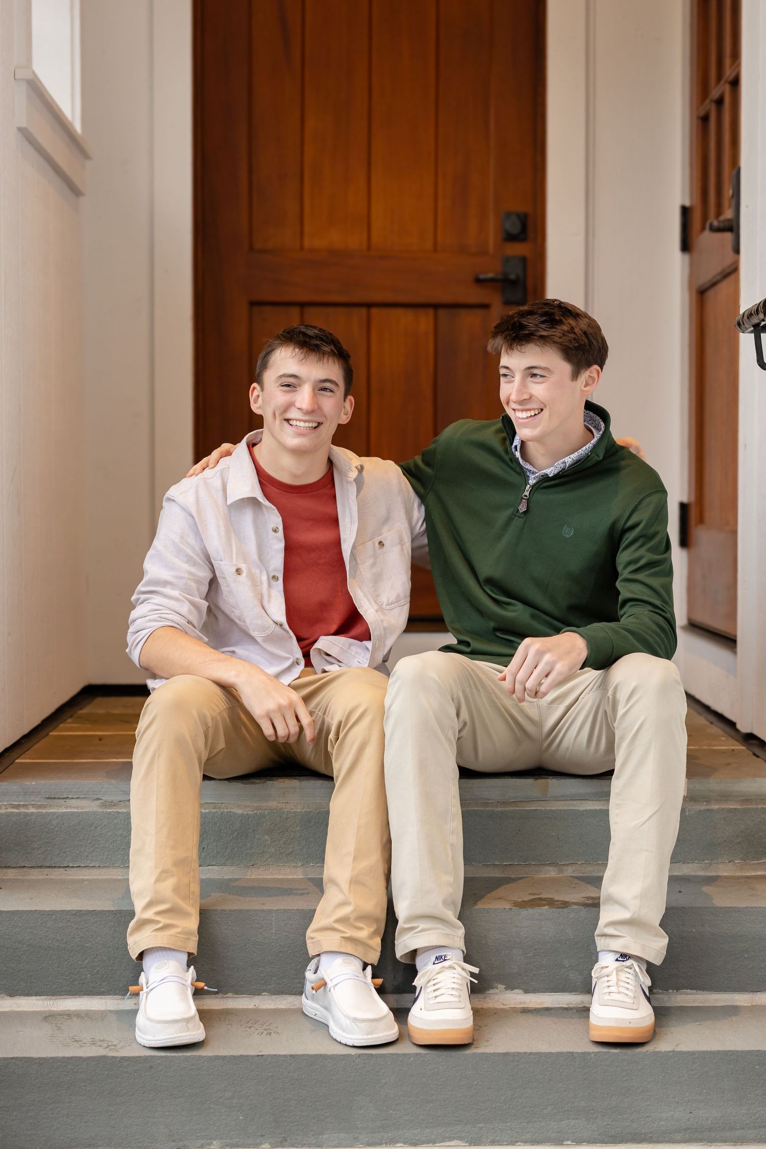 Group portrait on front porch steps showing casual fall attire in warm earth tones.