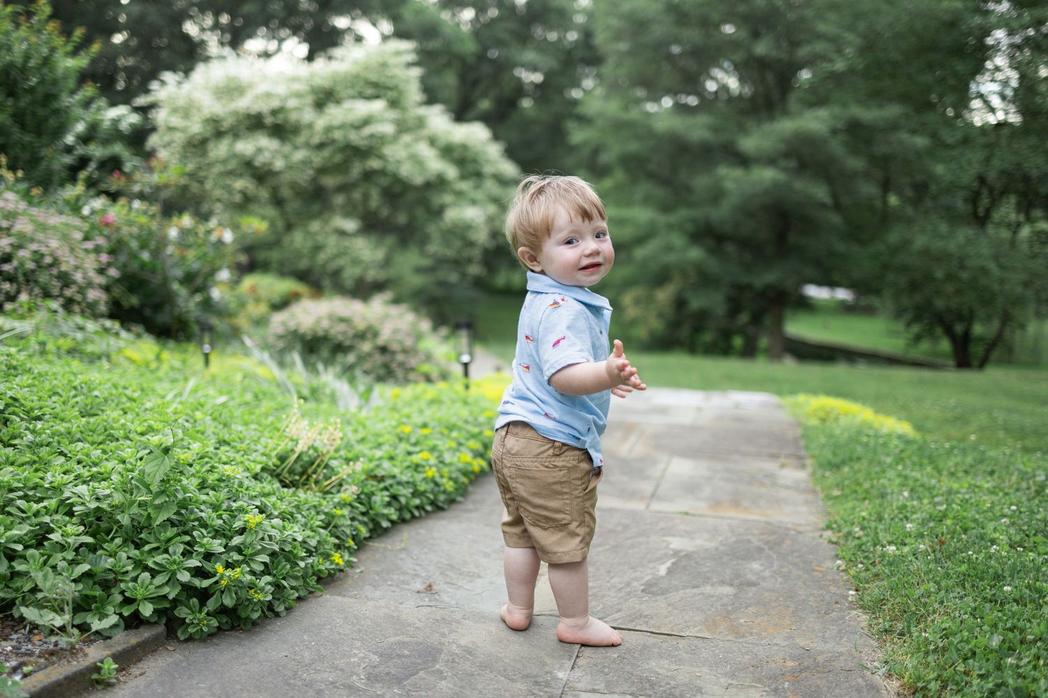 Toddler surrounded by lush green grass at Donegal Presbyterian Church in Mount Joy, PA with Lancaster, PA photographer.
