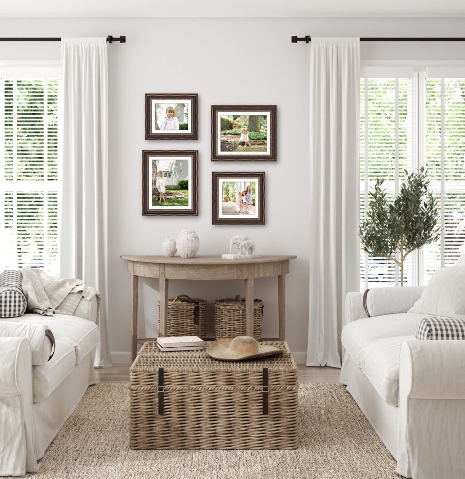 Bright farmhouse living room with white sofas, wicker trunk coffee table, wood console, and gallery wall of framed nature photos.