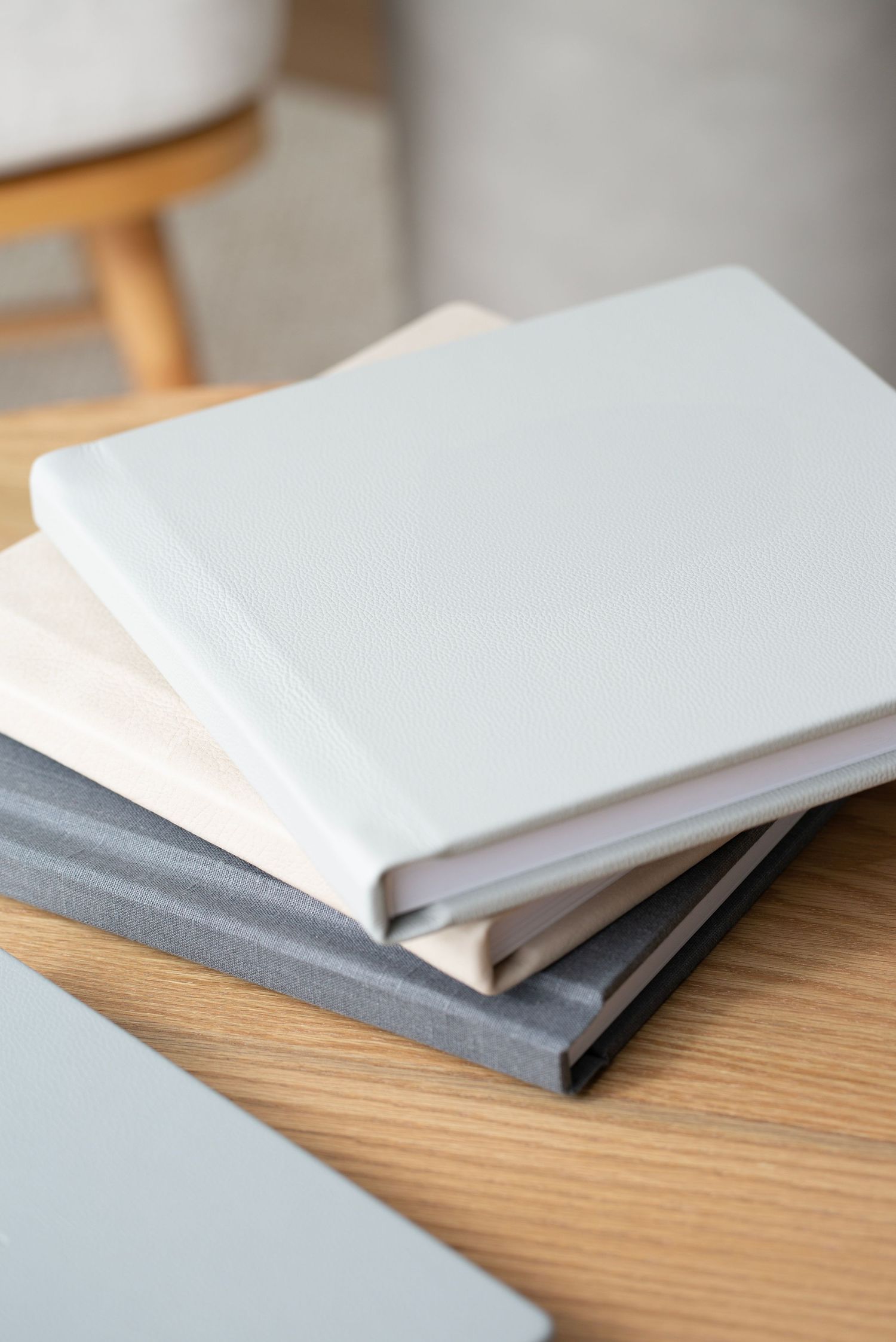 A series of white and gray notebooks arranged in a row on a wooden surface showing different angles and perspectives.