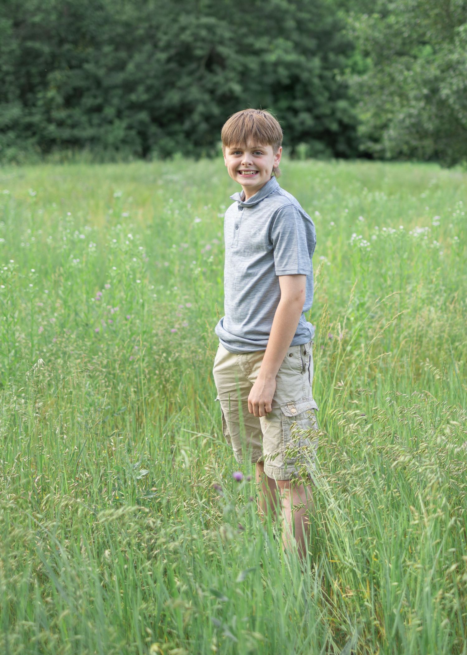 teen boy in tall grassy field at Donegal Presbyterian Church in Mount Joy, PA during family session with Lancaster, PA photographer