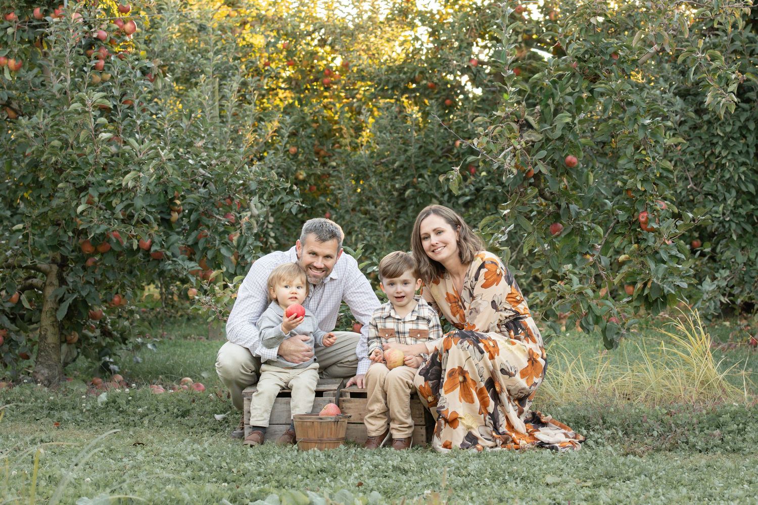 Family relaxing on grass with autumn foliage and natural lighting.