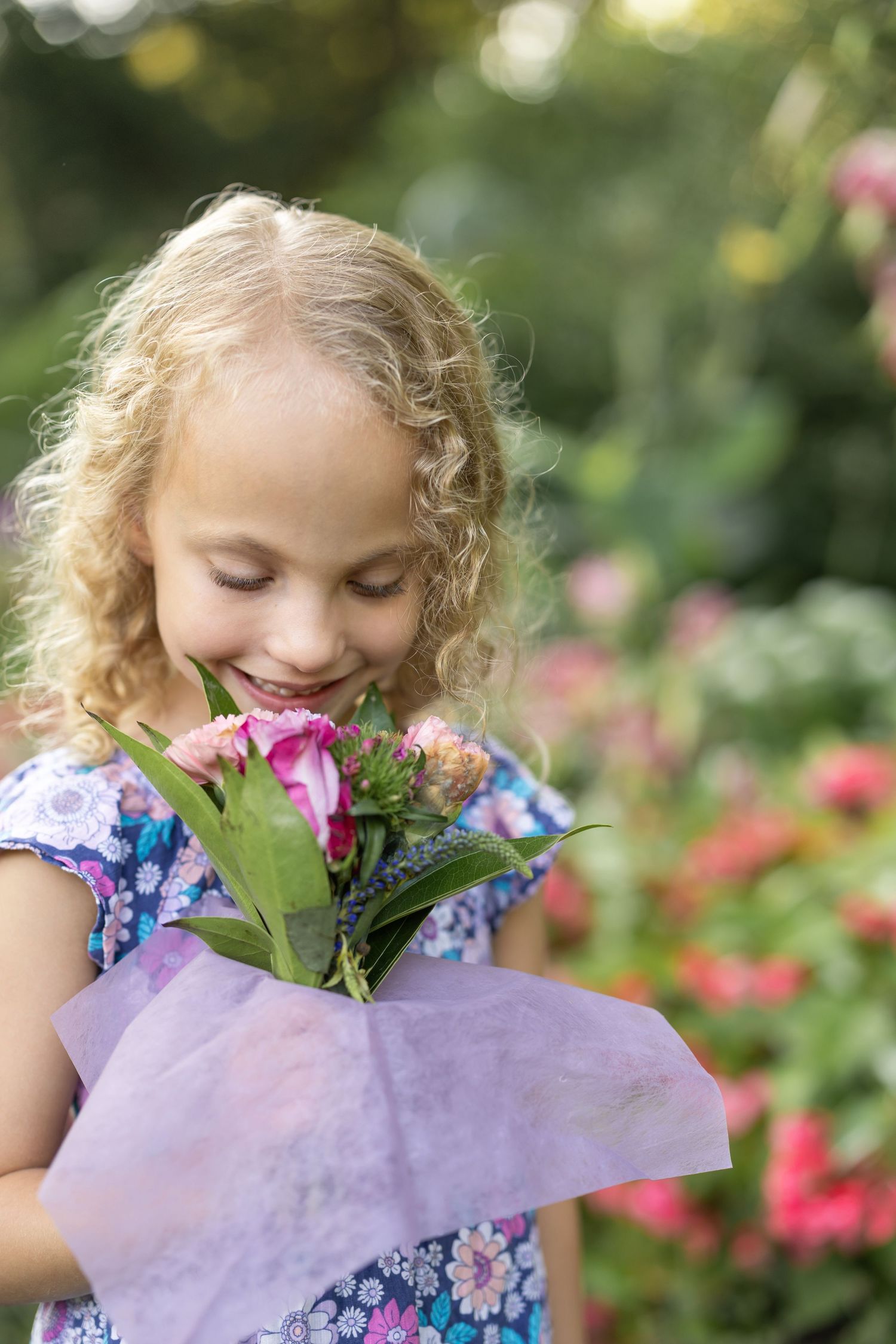 A young girl smells a vibrant bouquet of flowers, image by a Lancaster, PA family photographer.