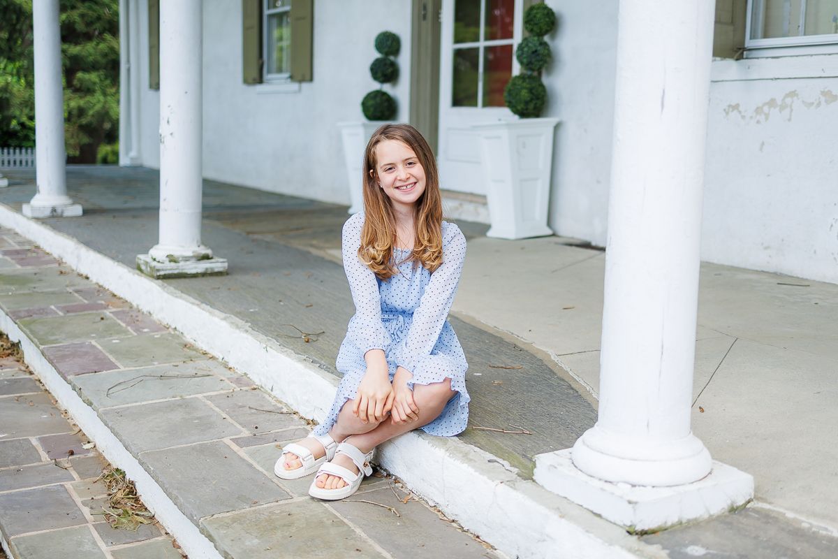 A family milestone session in Gap, PA at White Chimneys Estate. A beautiful teen girl sitting on stone steps.