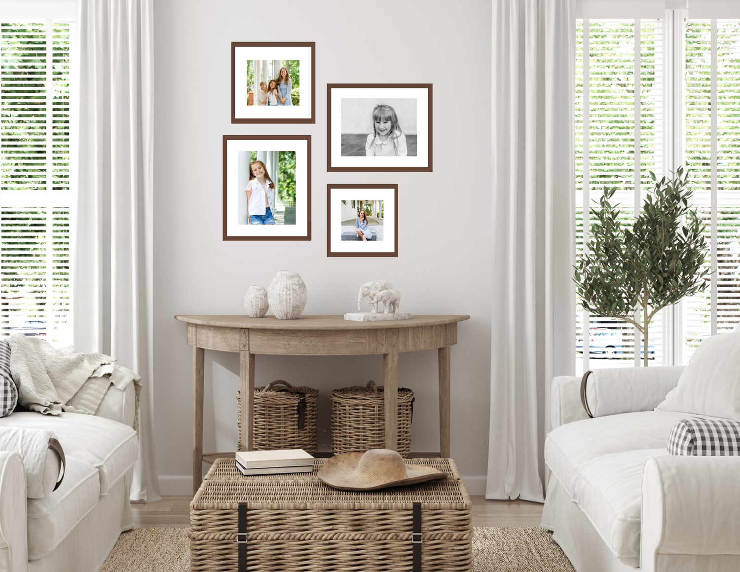 Bright living room with white sofas, a wooden console table, wicker baskets, and a gallery wall of framed photos near draped windows.