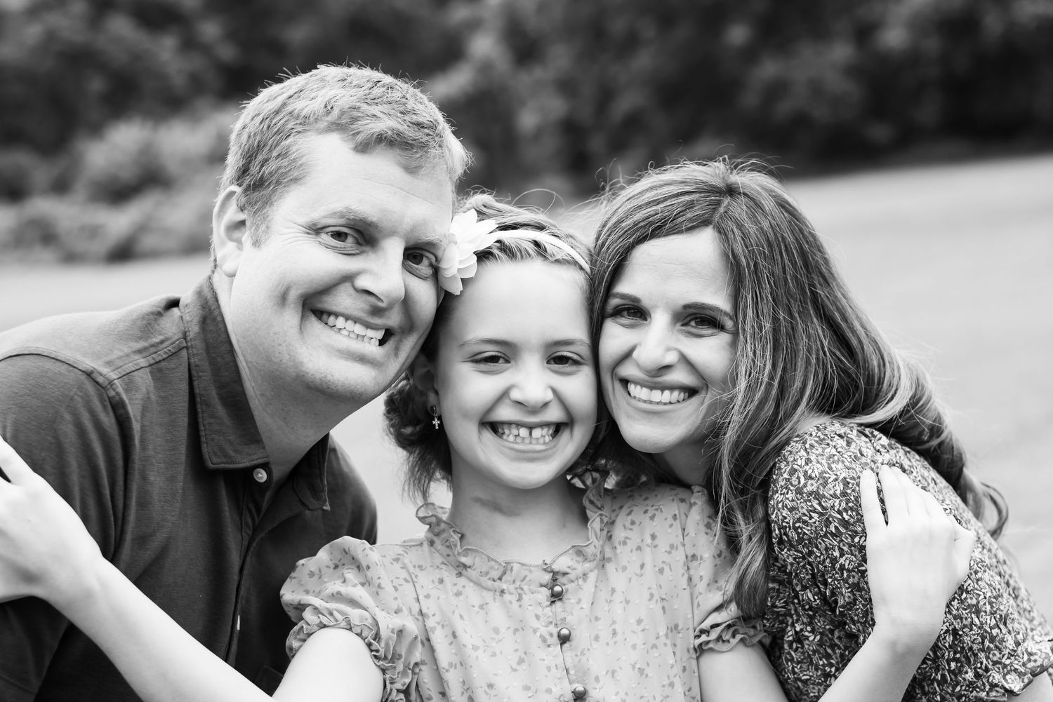 A week away non-profit in Lancaster, PA. Mother and father smile with their young daughter in a black and white family portrait.