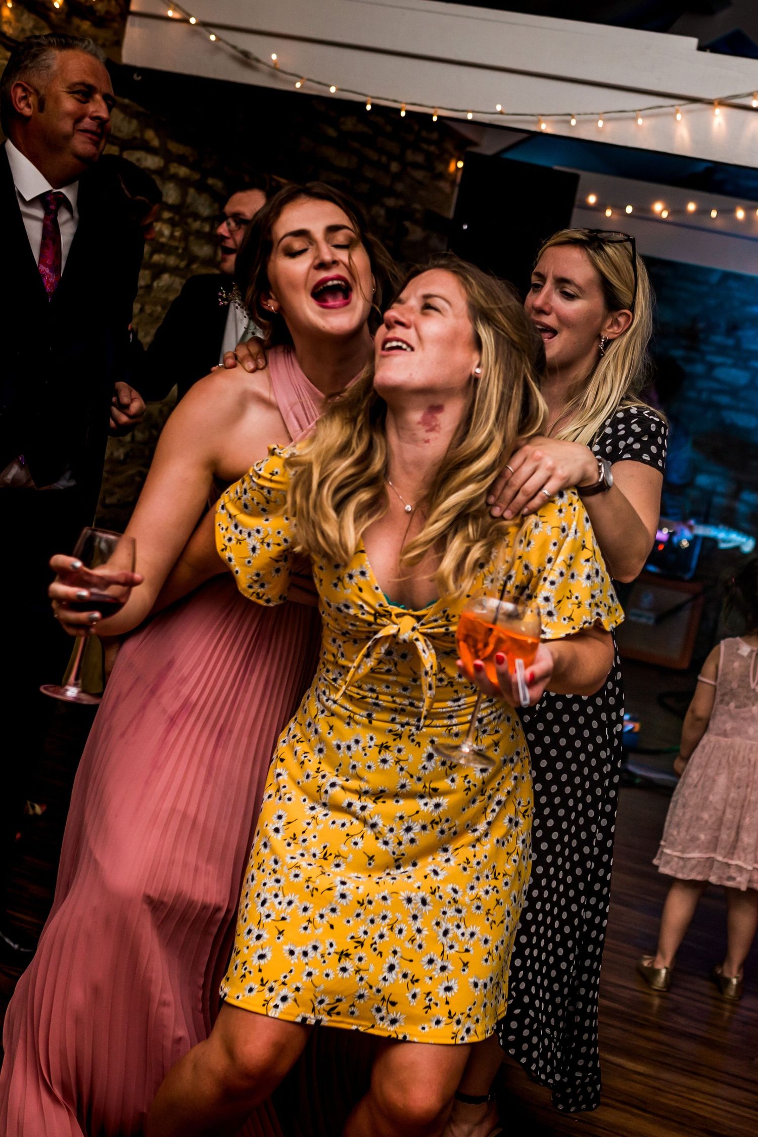 Candid photo of friends dancing and laughing at a party at the Farm at South Cover wedding venue by Nova Scotia wedding photographer.