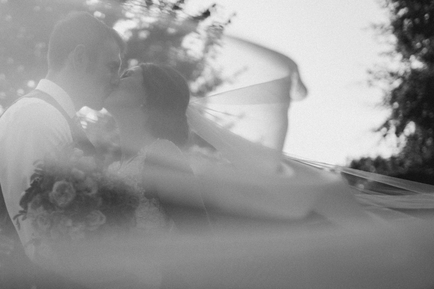 Blurry black and white artistic photograph through water showing abstract silhouettes at wedding venue the Farm at South Cove.