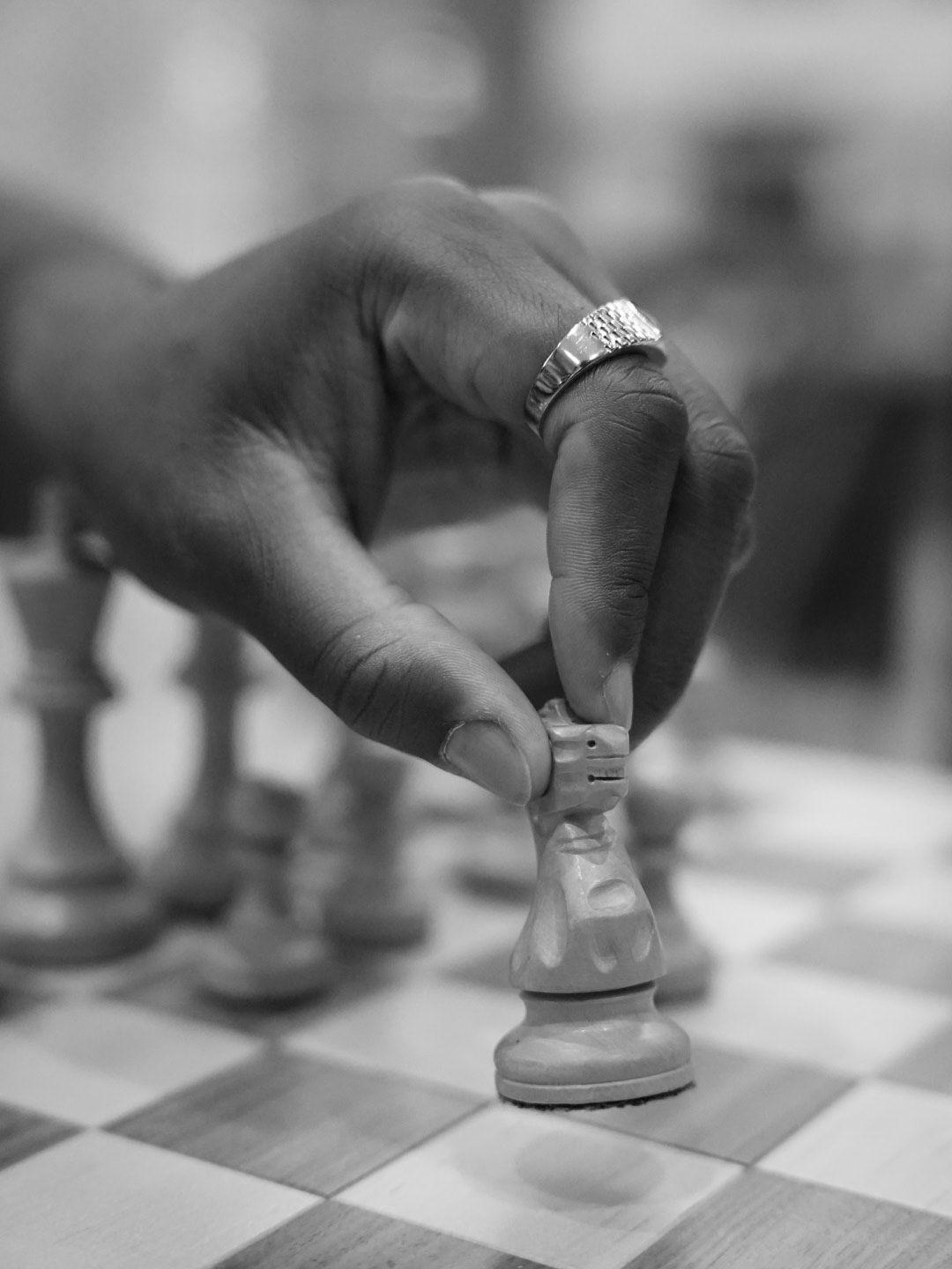 Chess pieces being moved across a black and white board in sequential motion shots.