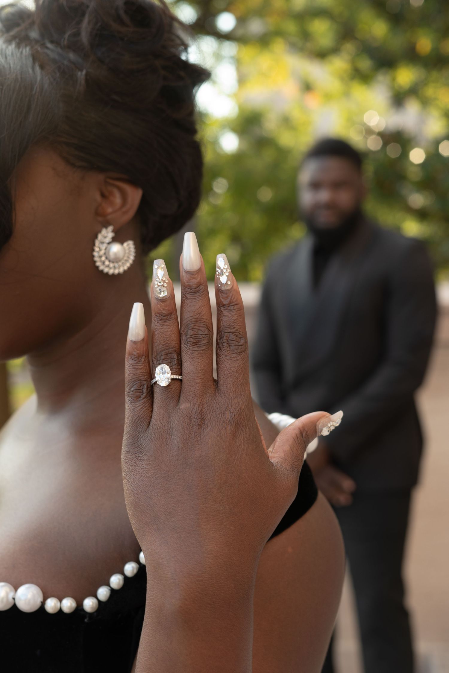 Close-up shots of hands wearing elegant pearl and crystal jewelry against a soft bokeh background.