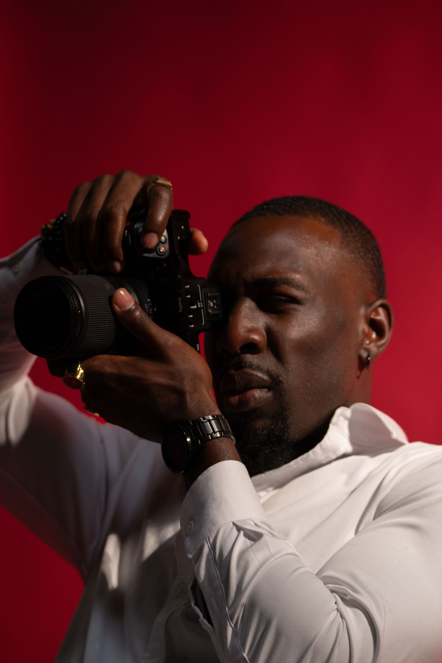 Person in white shirt drinking from bottle against red background in artistic photography sequence.