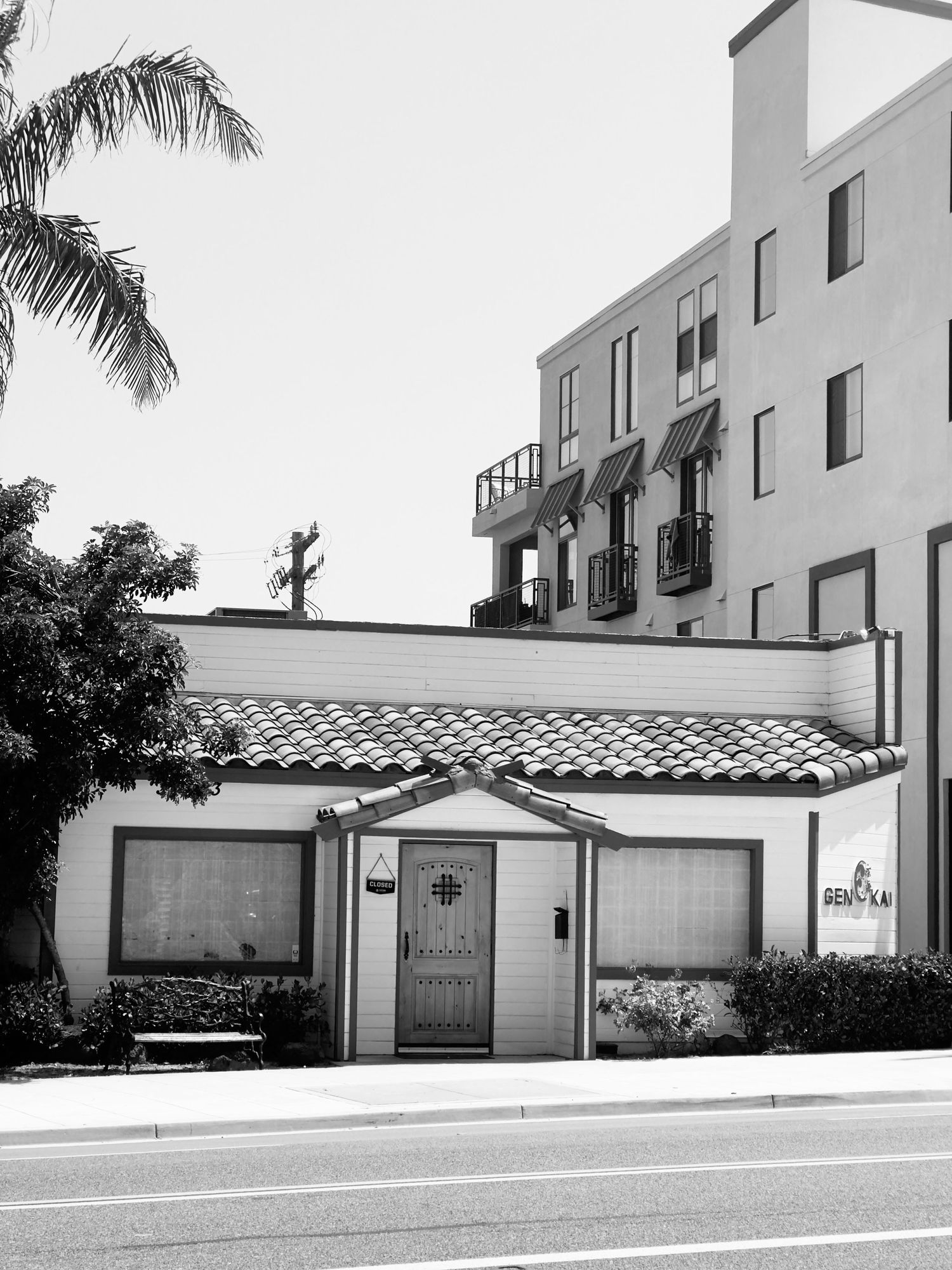 White stucco buildings with Spanish-style tile roofs and garage doors along a street.