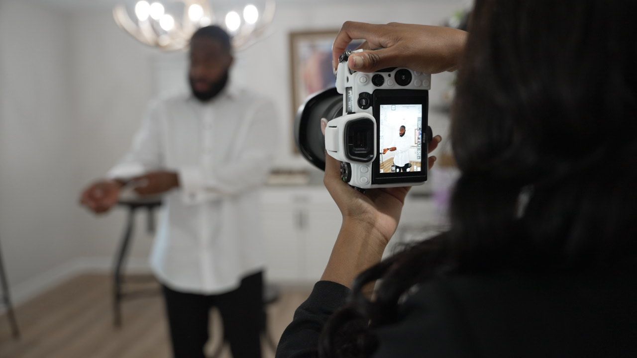 People using cameras and phones to capture moments at an indoor event.
