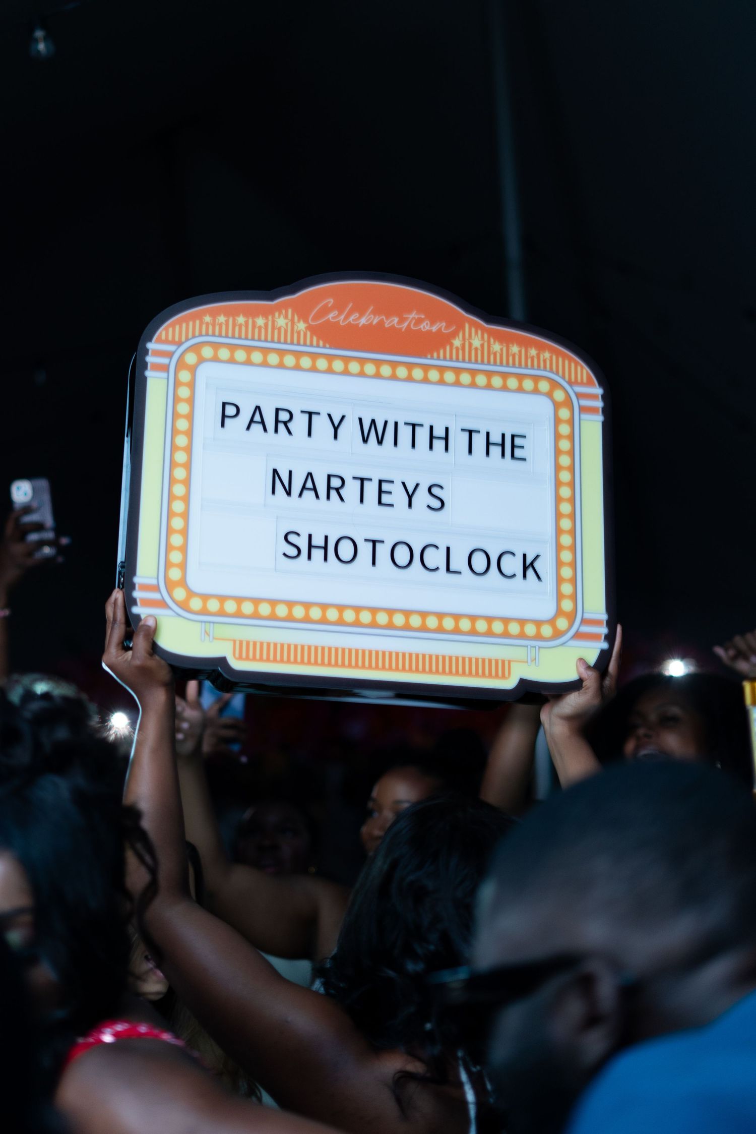 Illuminated event signage showing 'Party with the' text against dark background.
