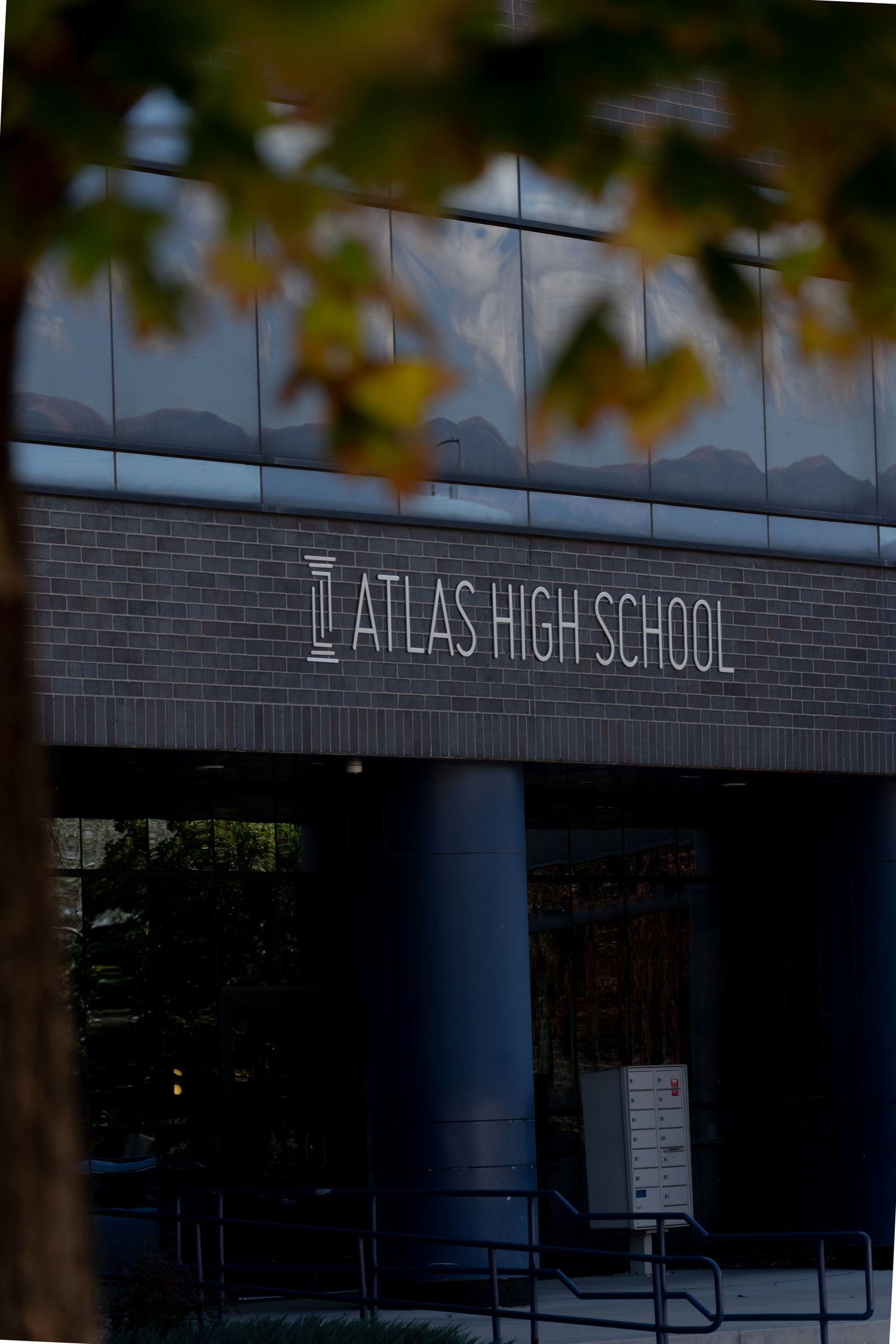Exterior view of Dallas High School building entrance with blue columns and brick facade in natural lighting.