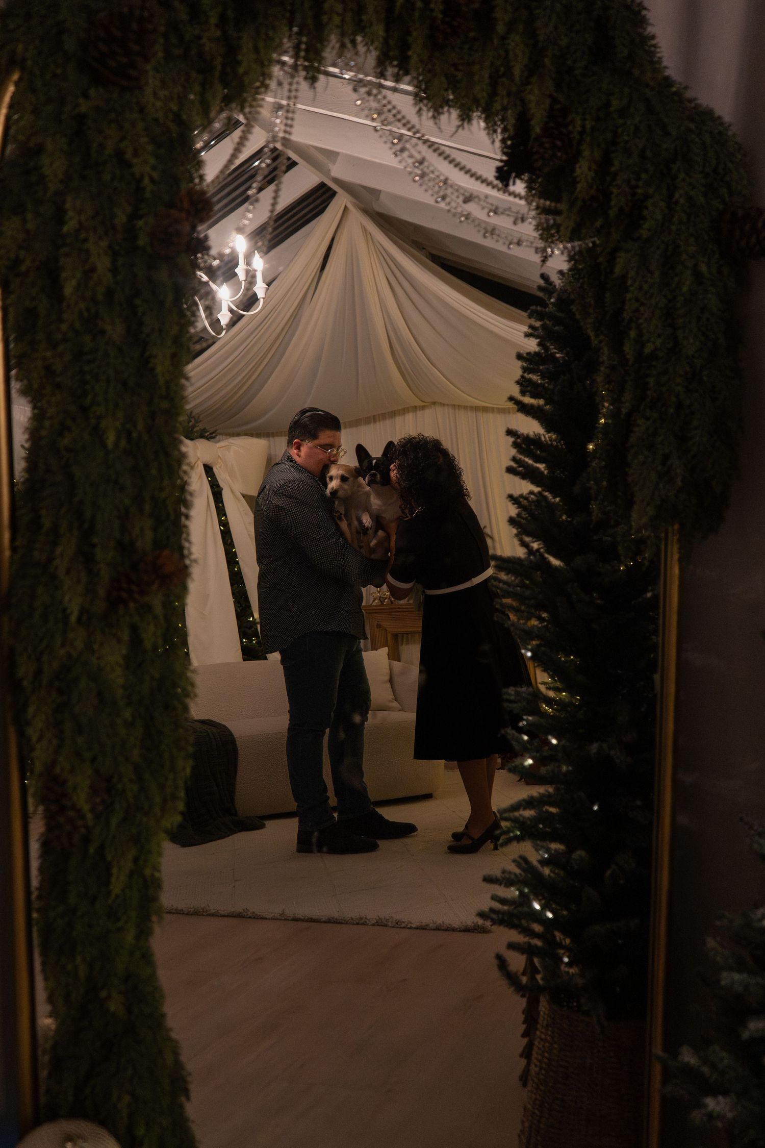 A couple shares a romantic dance under an elegant white tent at an evening event.