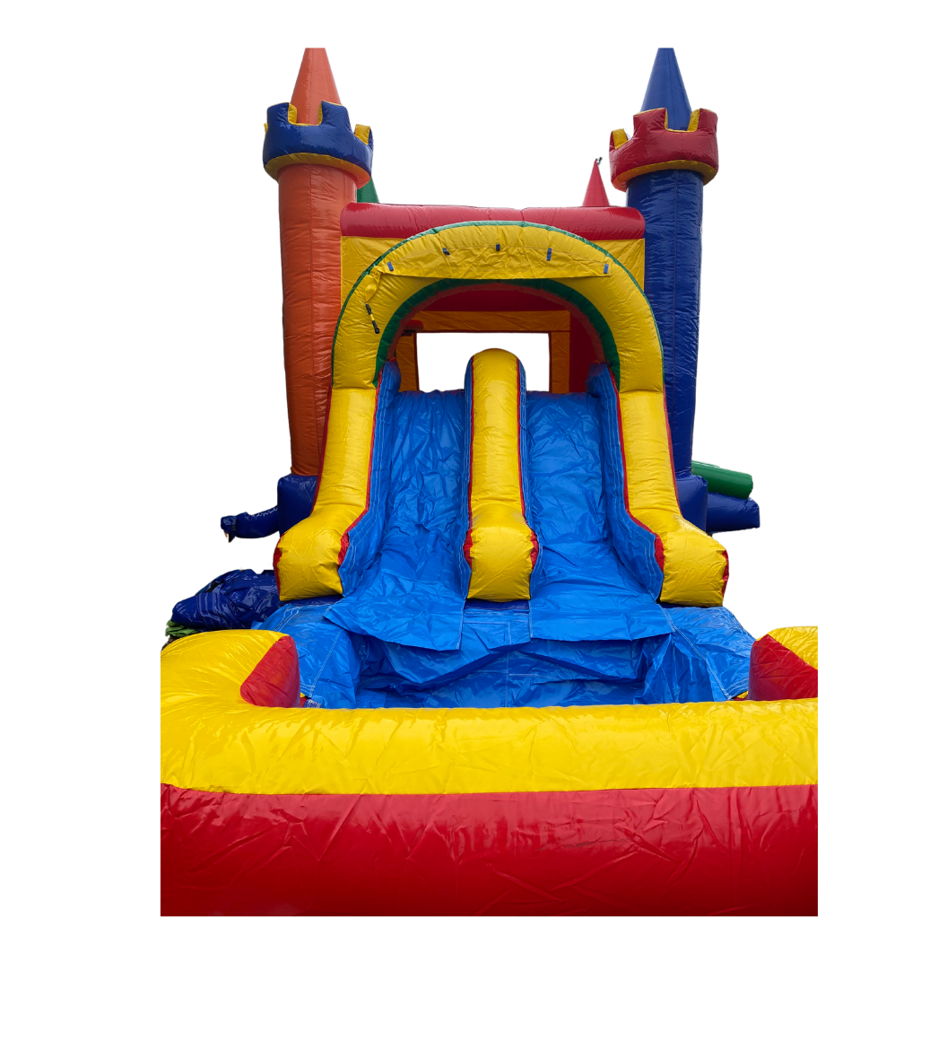 Castle-themed bounce house with slide featuring bright red, blue, and yellow colors.