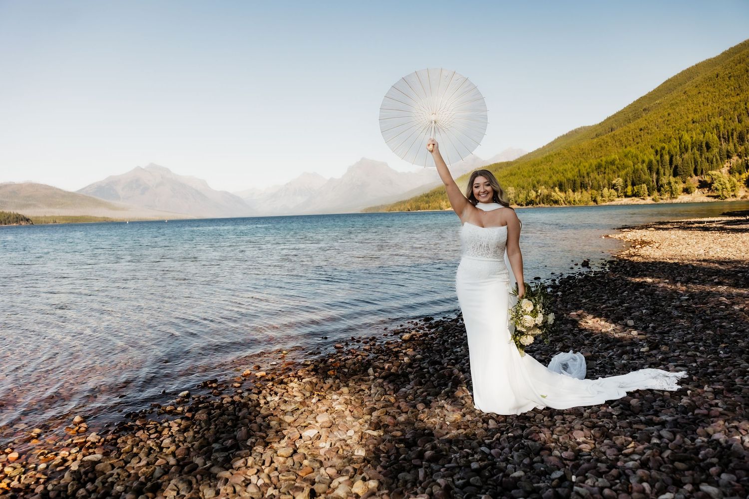 A romantic wedding photo series captured along a scenic mountain lake shore with dramatic natural lighting and landscapes.