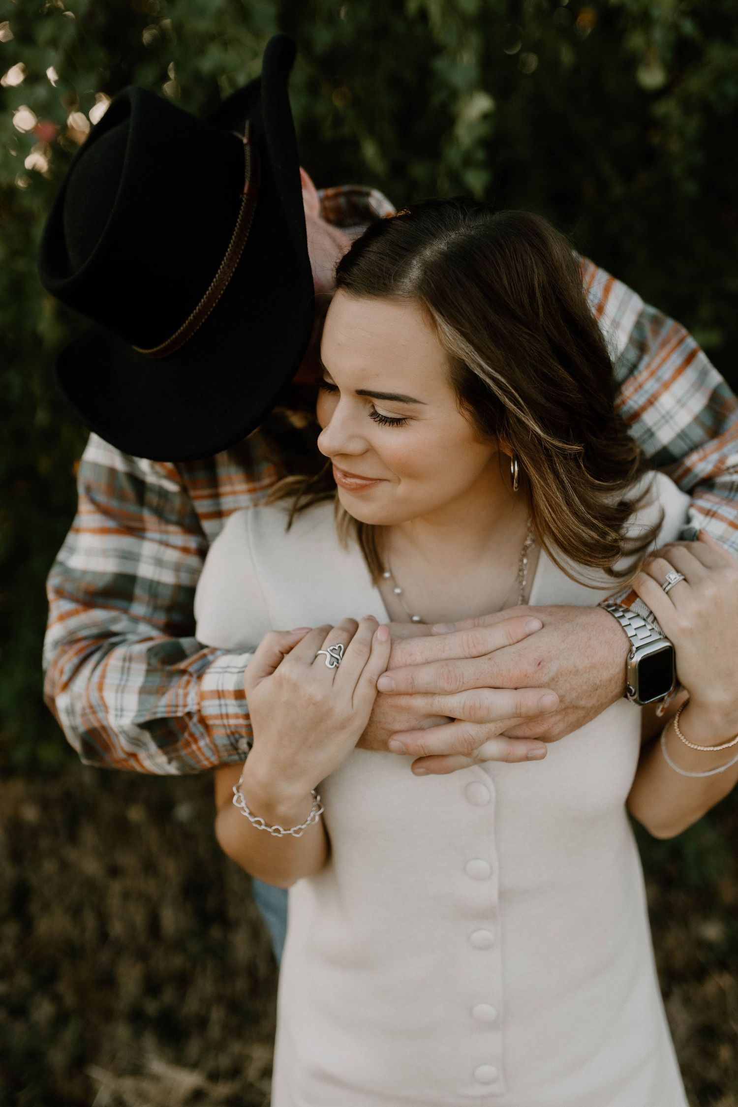 A romantic outdoor embrace between a couple shows tender affection as they share an intimate moment in nature.