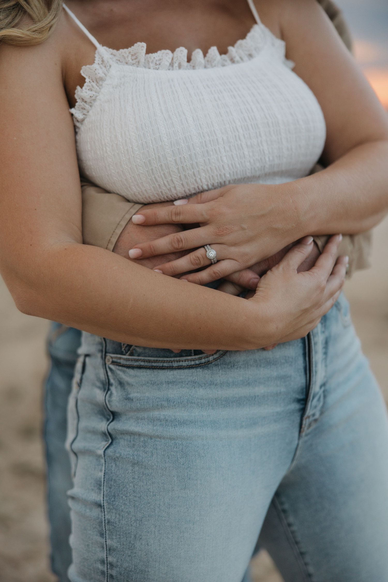 Close-up shots of a woman wearing a white ruched top and light denim jeans, showing midsection details.