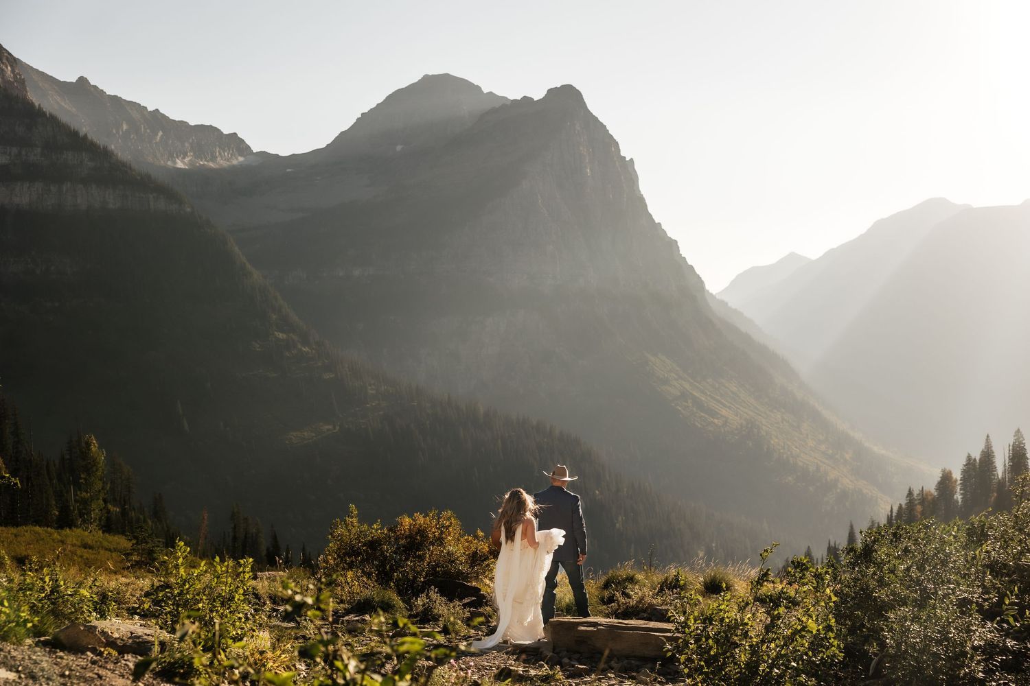 Scenic mountain landscape at sunset with golden light illuminating rugged peaks and valleys in a national park.